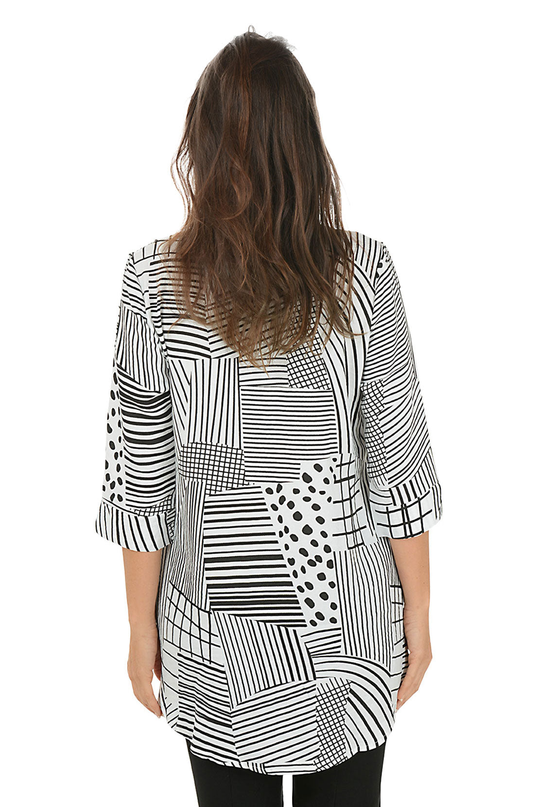 Woman wearing a black and white patterned blouse with red accents on a white background. Back shot.