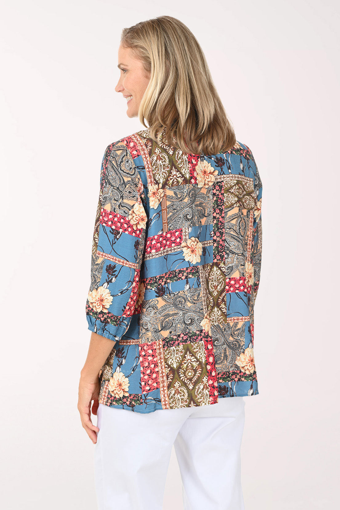 Woman wearing an open front multi colored top with a denim trim