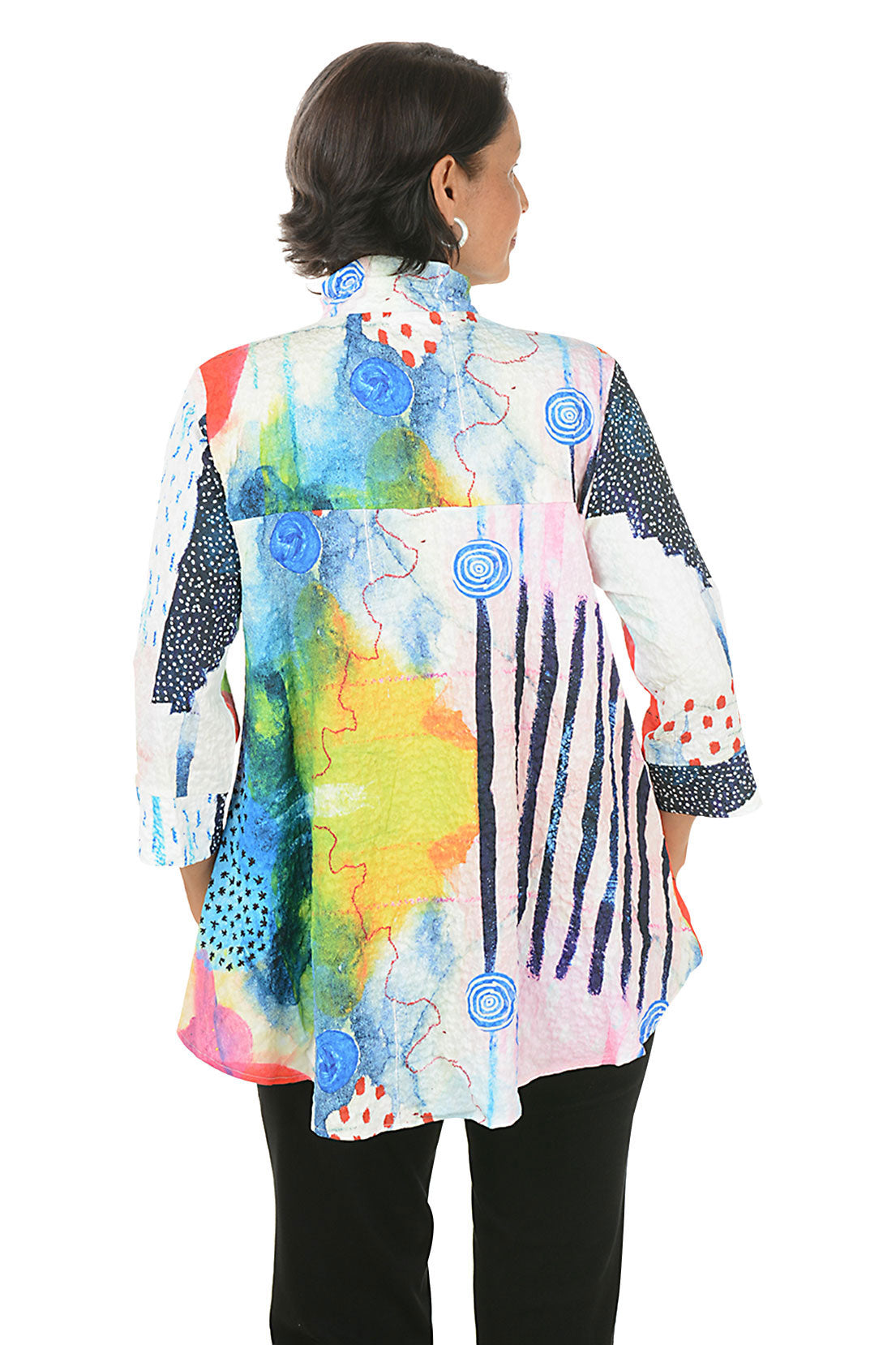 Woman wearing a colorful patterned blouse on a white background. Back shot.