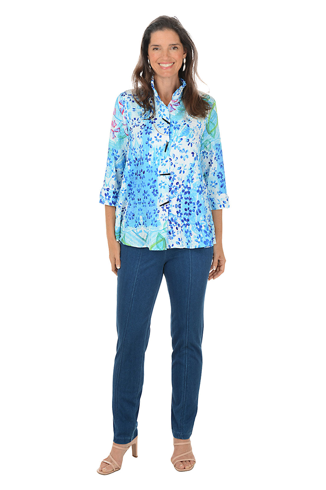 Woman wearing a blue floral blouse and jeans on a white background