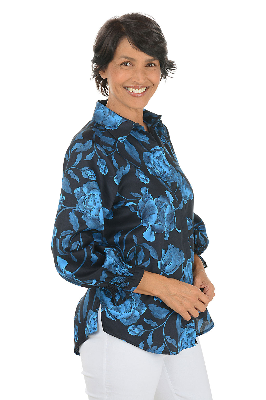 Woman wearing a black floral blouse with blue flowers on a white background - Side Shot