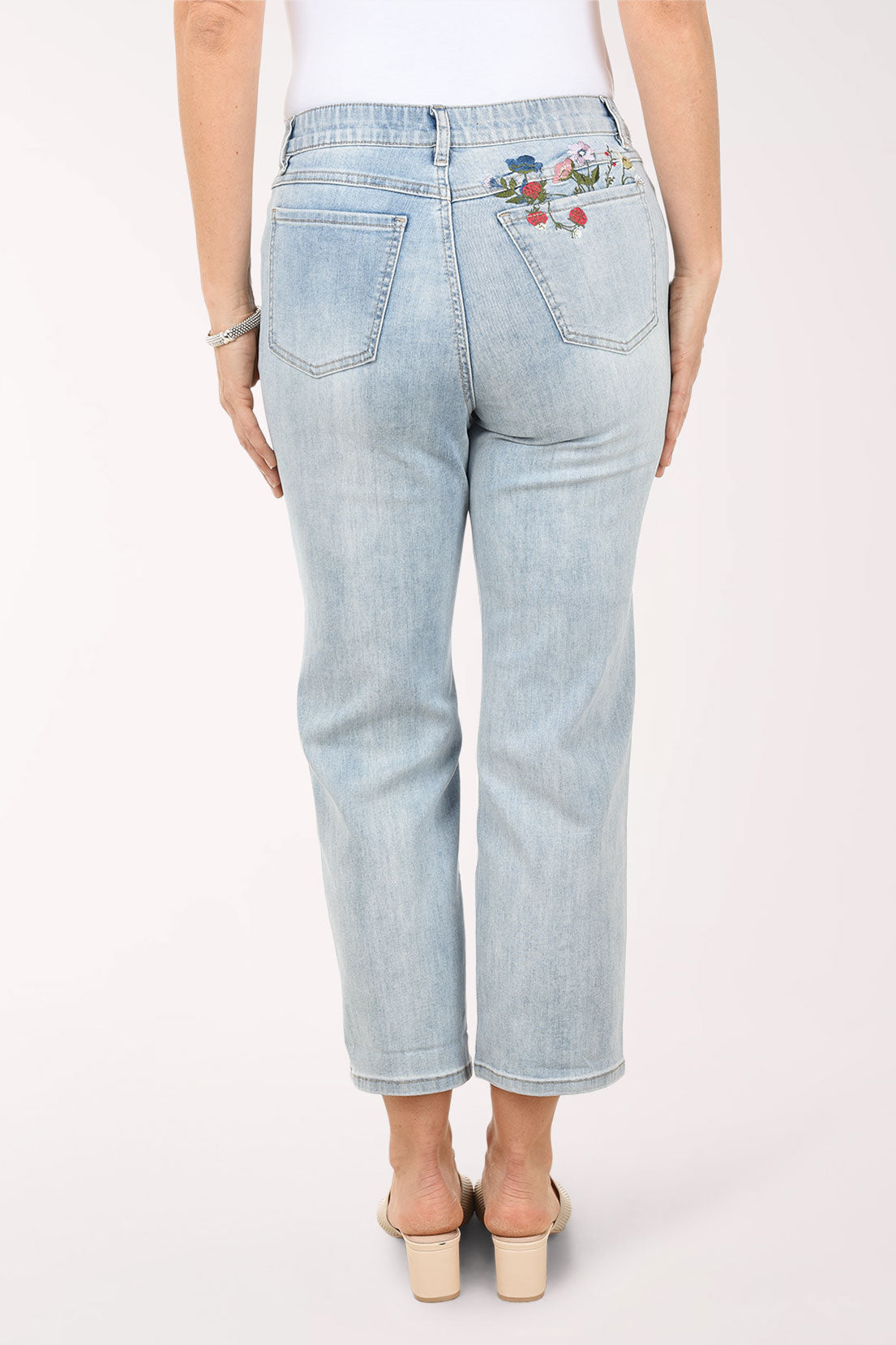 Light blue jeans with floral embroidery on a white background
