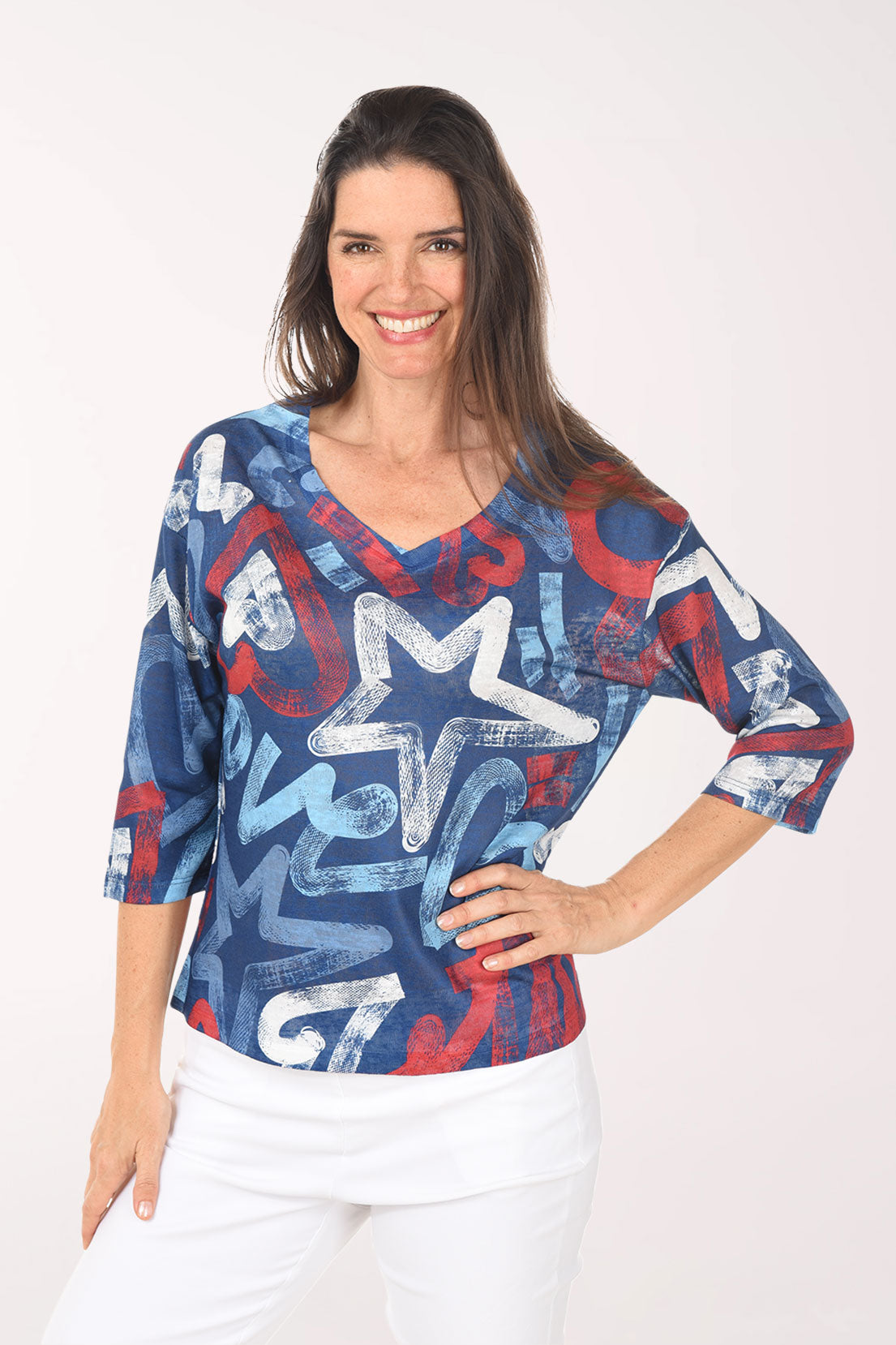 Woman wearing a colorful star-patterned top on a white background