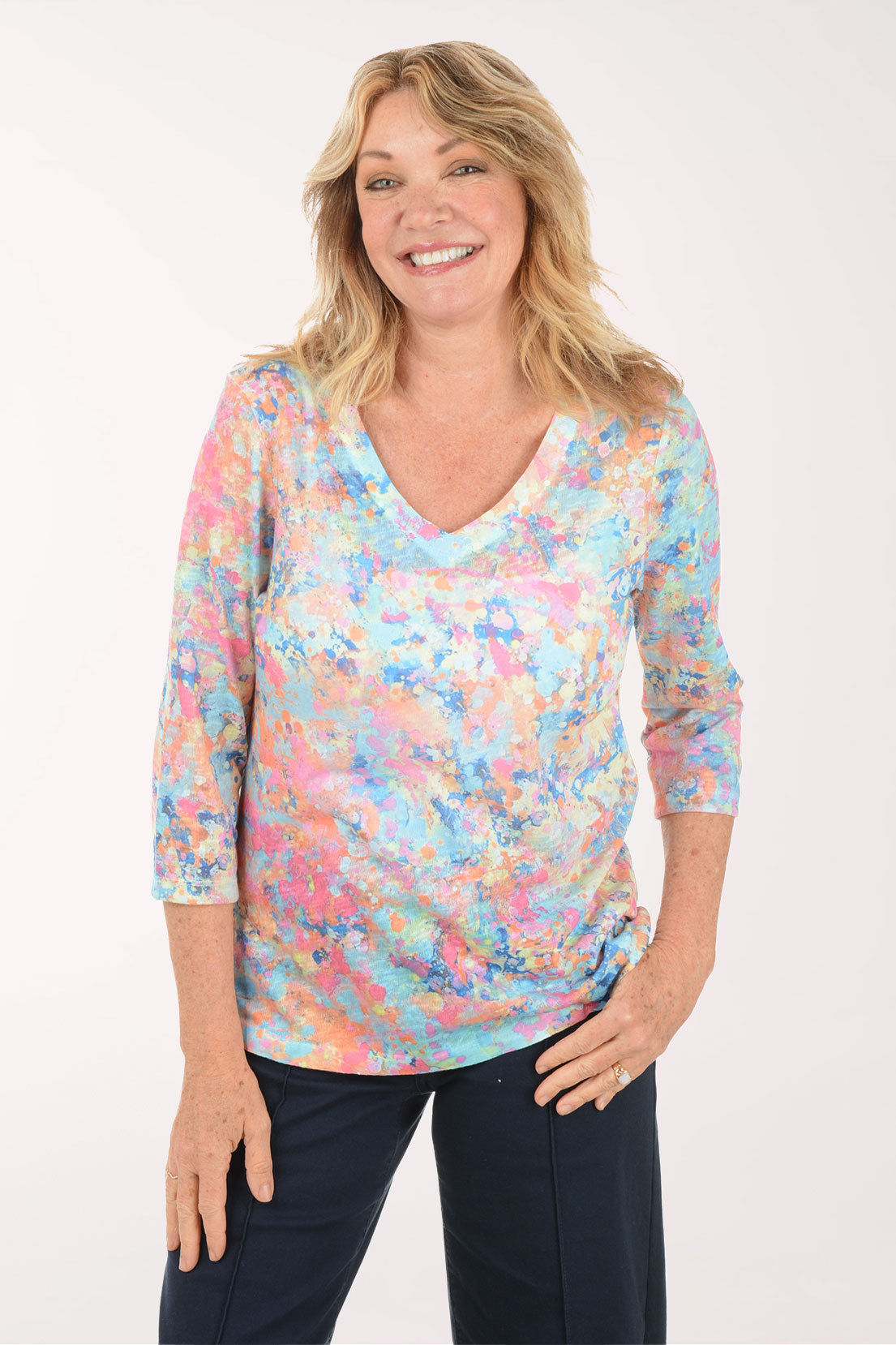 A woman wearing a multicolored v-neck 3/4 sleeve top.