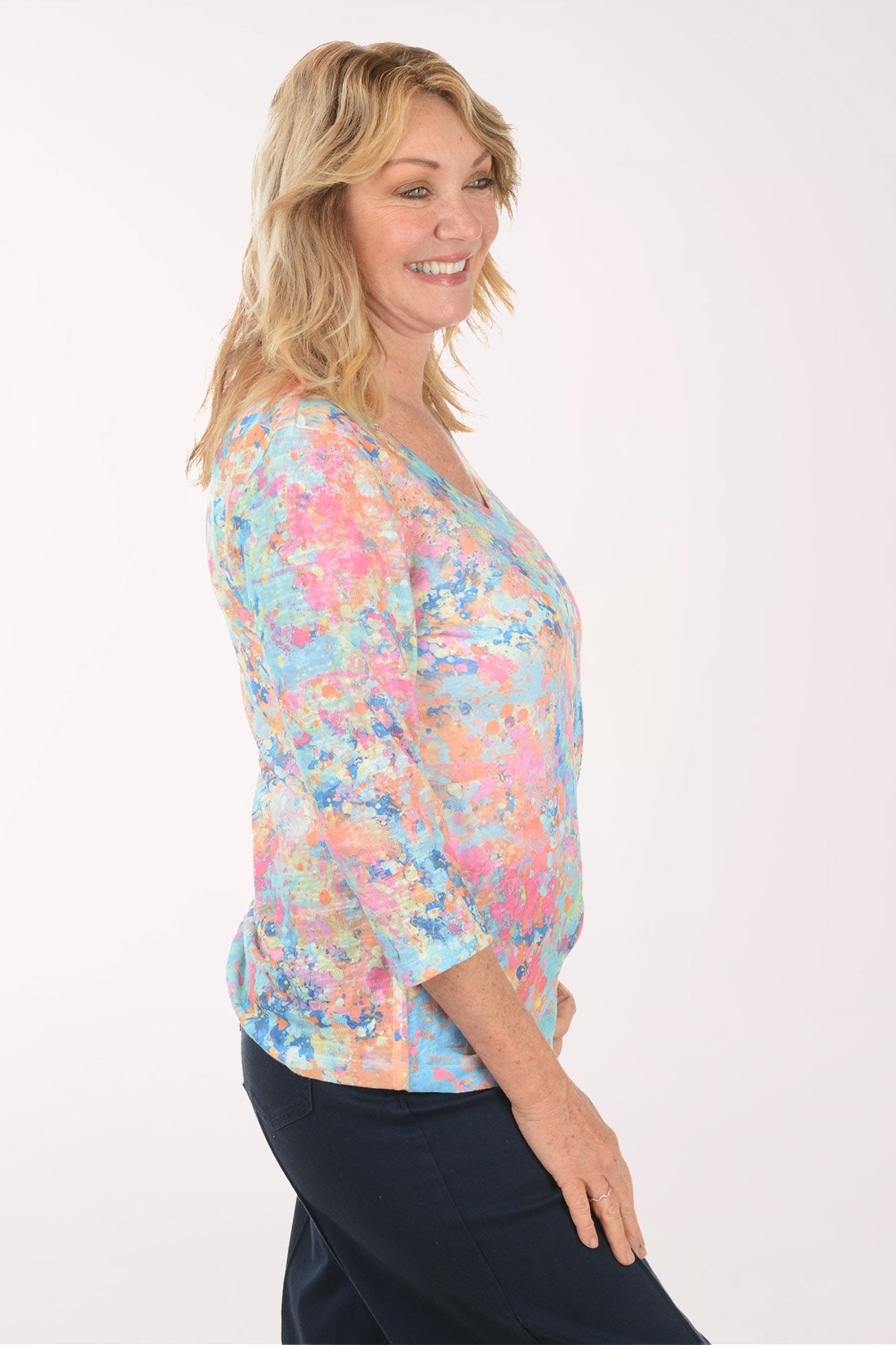 A woman wearing a multicolored v-neck 3/4 sleeve top.