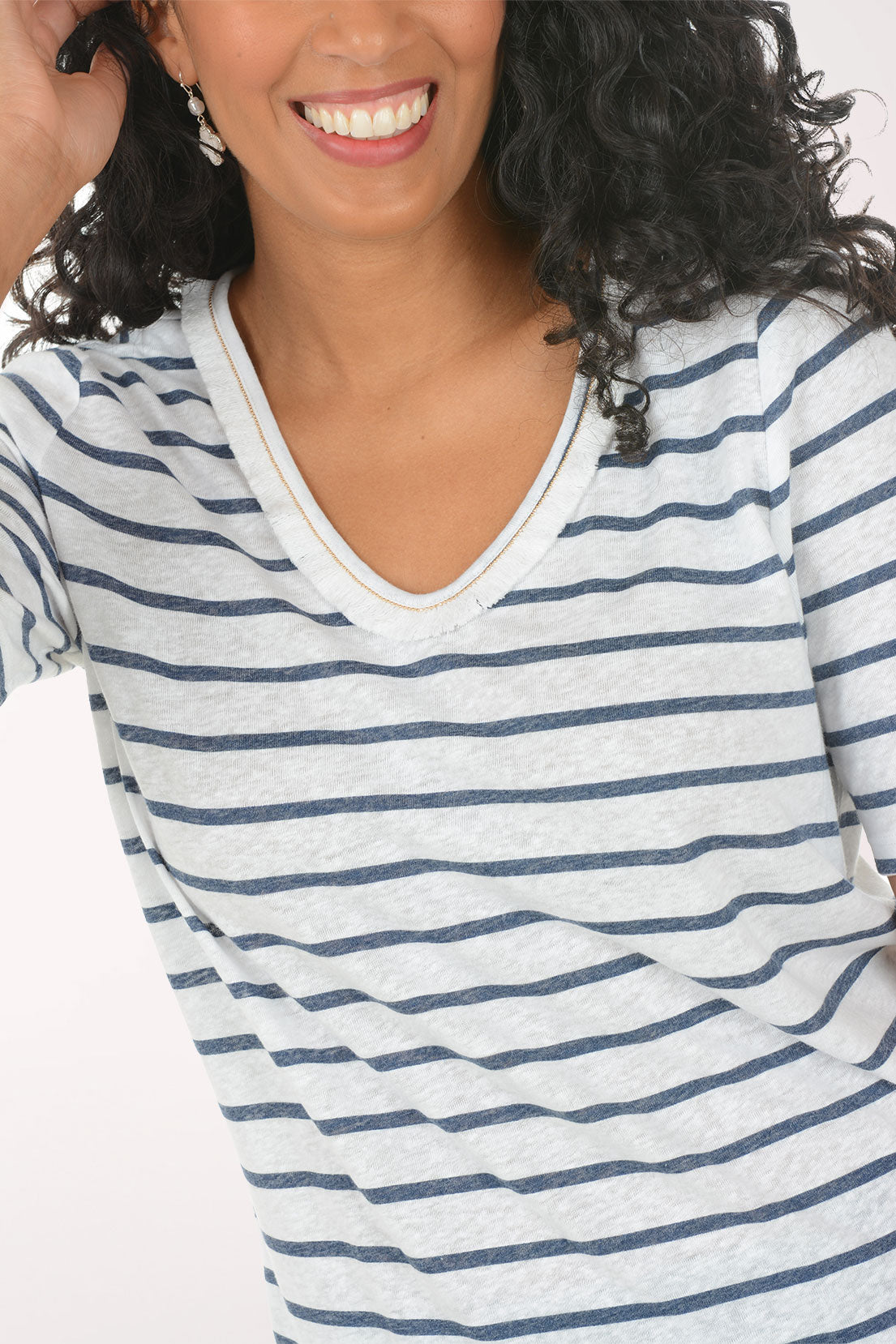 Woman wearing a striped shirt and jeans on a white background