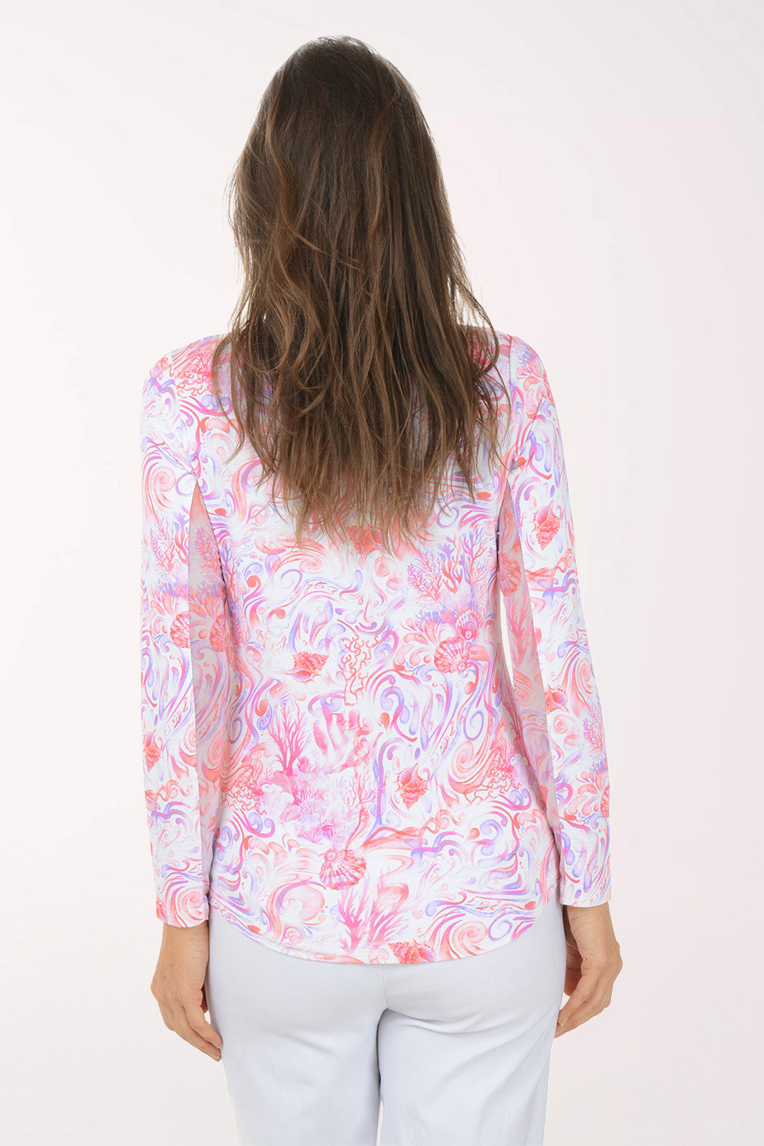 Woman wearing a colorful long-sleeve shirt with a white background