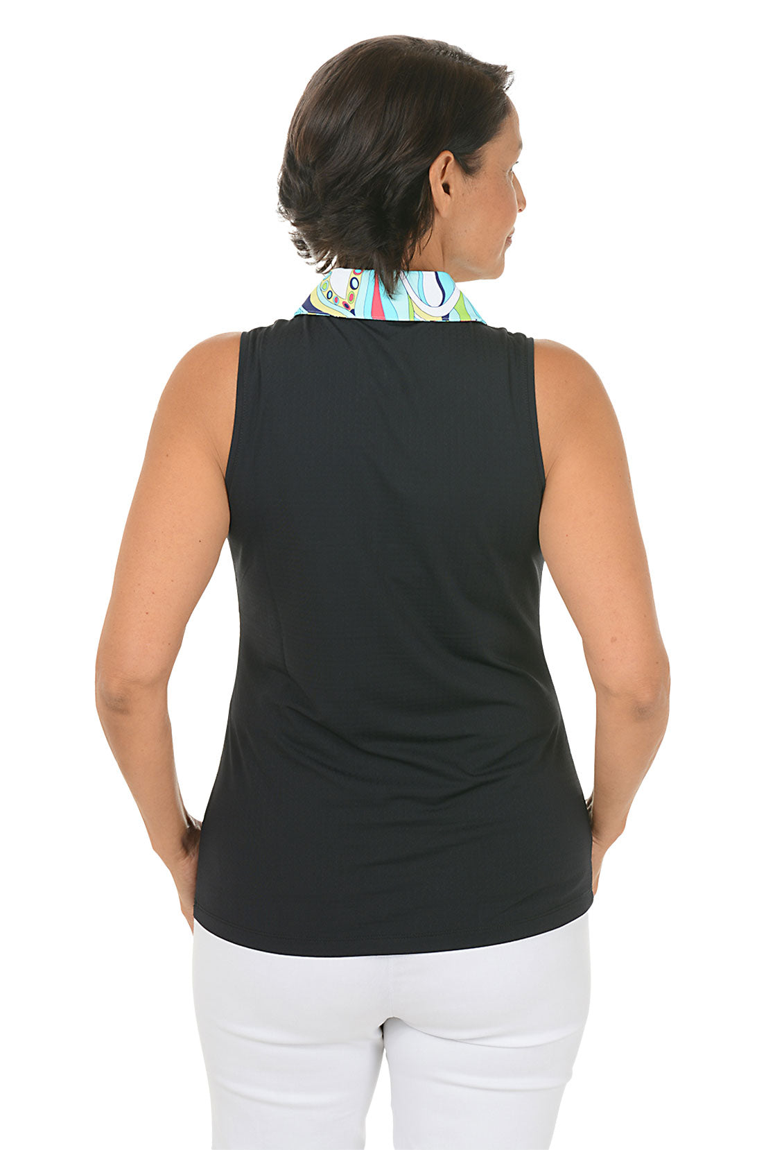 Woman wearing a black sleeveless top with a colorful collar and white pants on a white background. Back shot.