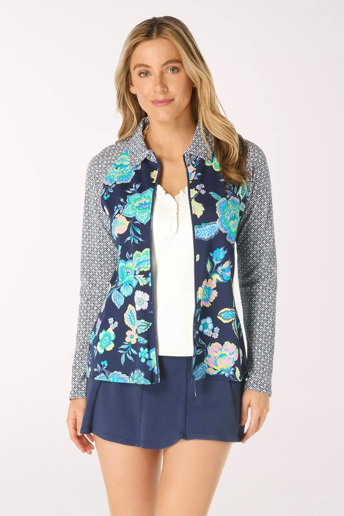 Woman wearing a navy floral rash guard with a patterned collar on a white background