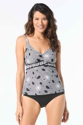 A woman wearing a floral allure v-neck tankini top in black and gray, with adjustable shoulder straps and a crossover banded empire waist.