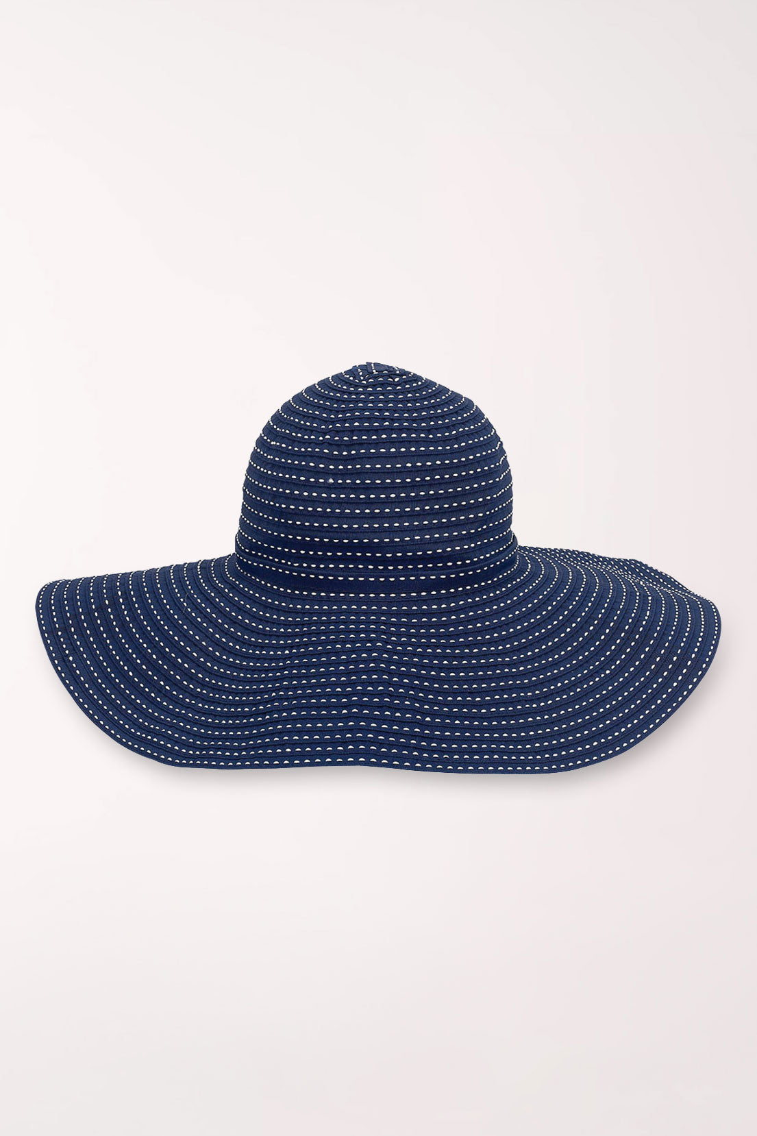 Navy blue sun hat with white polka dots on a light gray background
