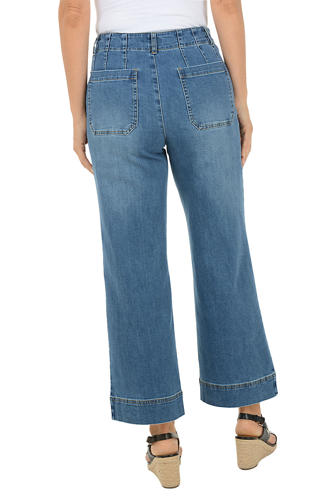 Person wearing blue jeans on a white background. Back shot.