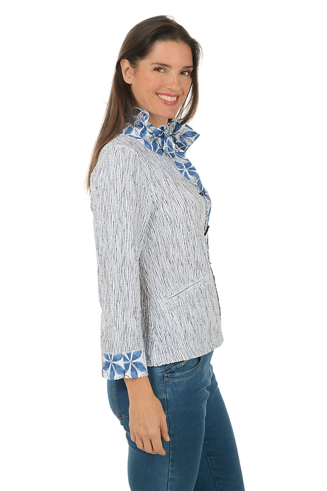 Woman wearing a blue and white patterned jacket with rolled-up sleeves on a white background