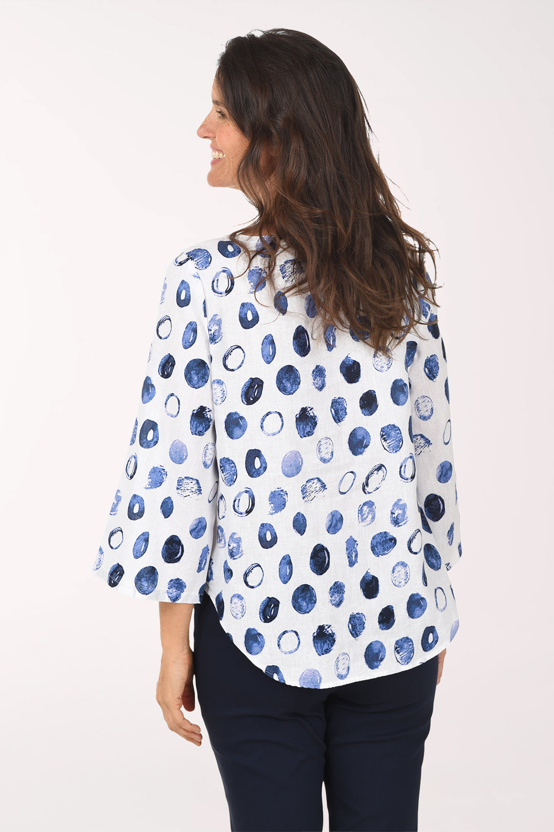 Woman wearing a white blouse with blue abstract pattern on a white background