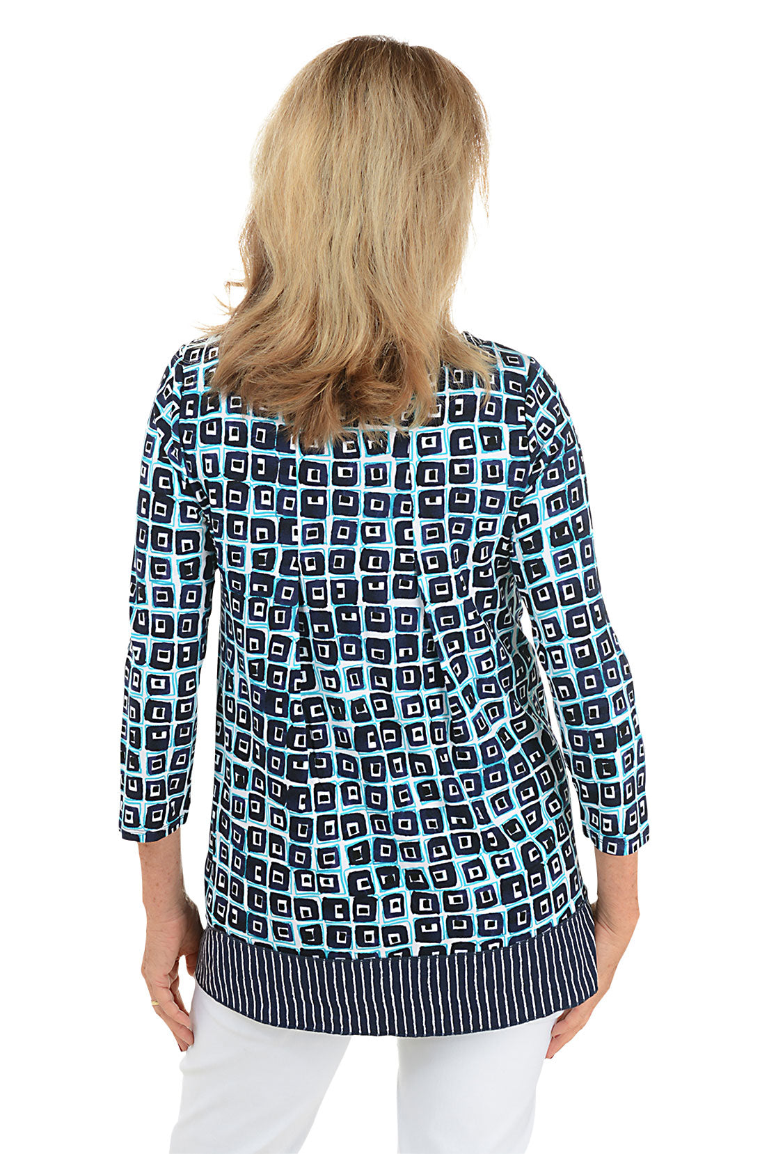 A back shot of a model wearing a blue and white geometric patterned tunic with a scoop neckline and pleated detail on the back.