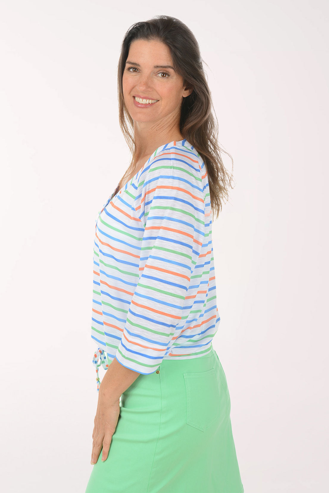 Woman wearing a colorful striped top and green skirt on a white background