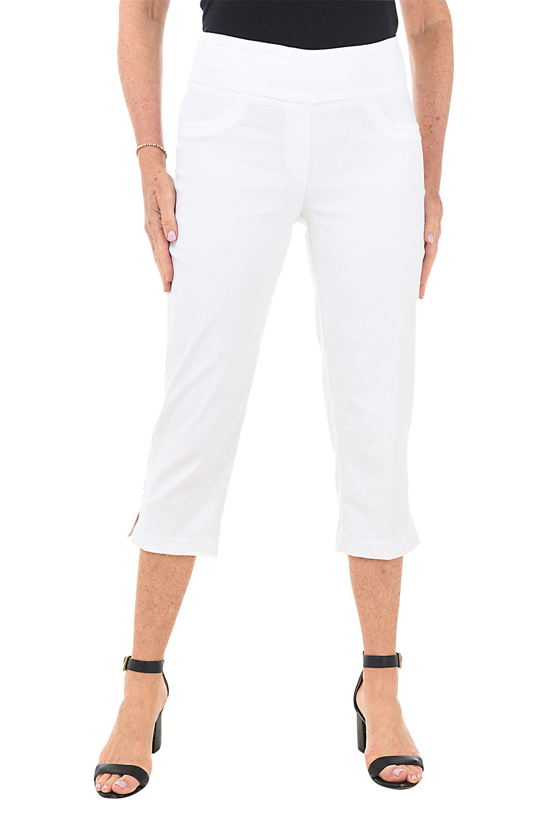 A front shot of a model wearing a pair of white pull-on capri pants with a studded lattice detail on the hemline, featuring an elasticized waistband and faux front pockets.