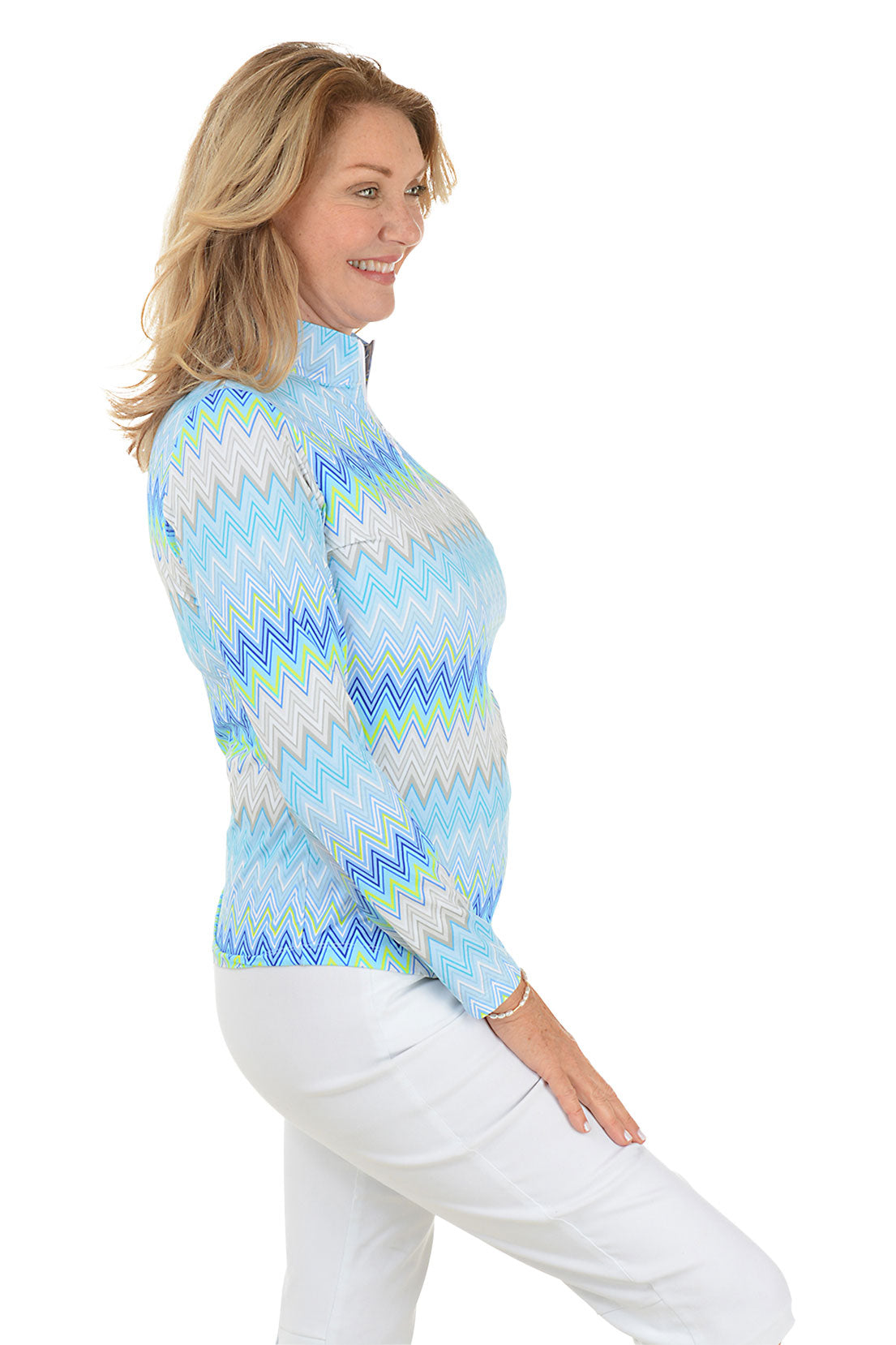 Woman wearing a colorful zigzag patterned shirt on a white background. Side shot.