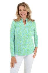 Woman wearing a green and blue patterned long-sleeve shirt on a white background.