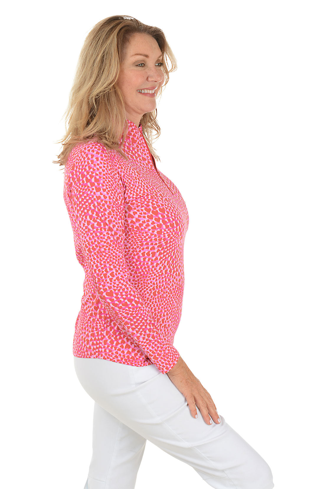 Woman wearing a pink patterned long-sleeve top on a white background. Side shot.