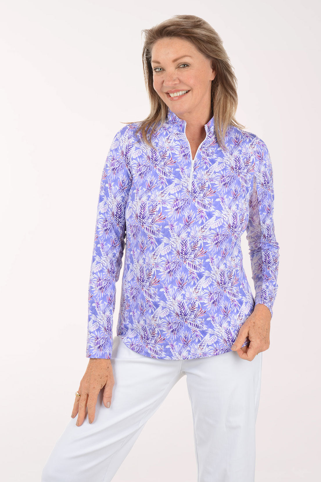 Woman wearing a purple floral patterned shirt against a white background