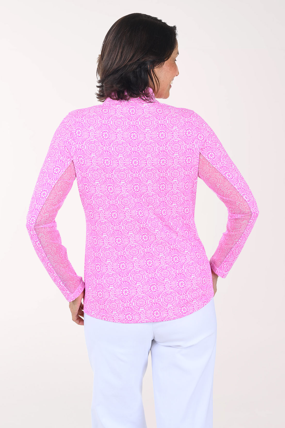 Woman wearing a pink patterned long-sleeve shirt on a white background