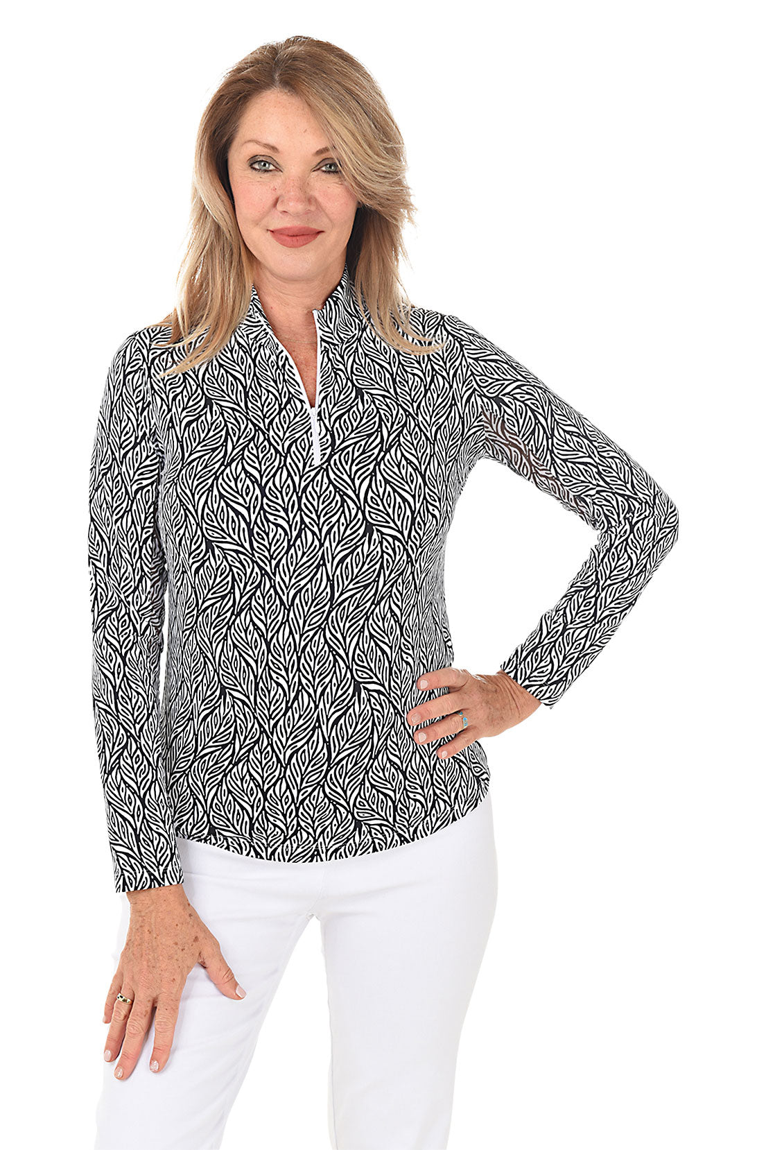 A woman wearing a black and white geometric patterned sun shirt with a mock neckline, long sleeves, and a quarter-zip.
