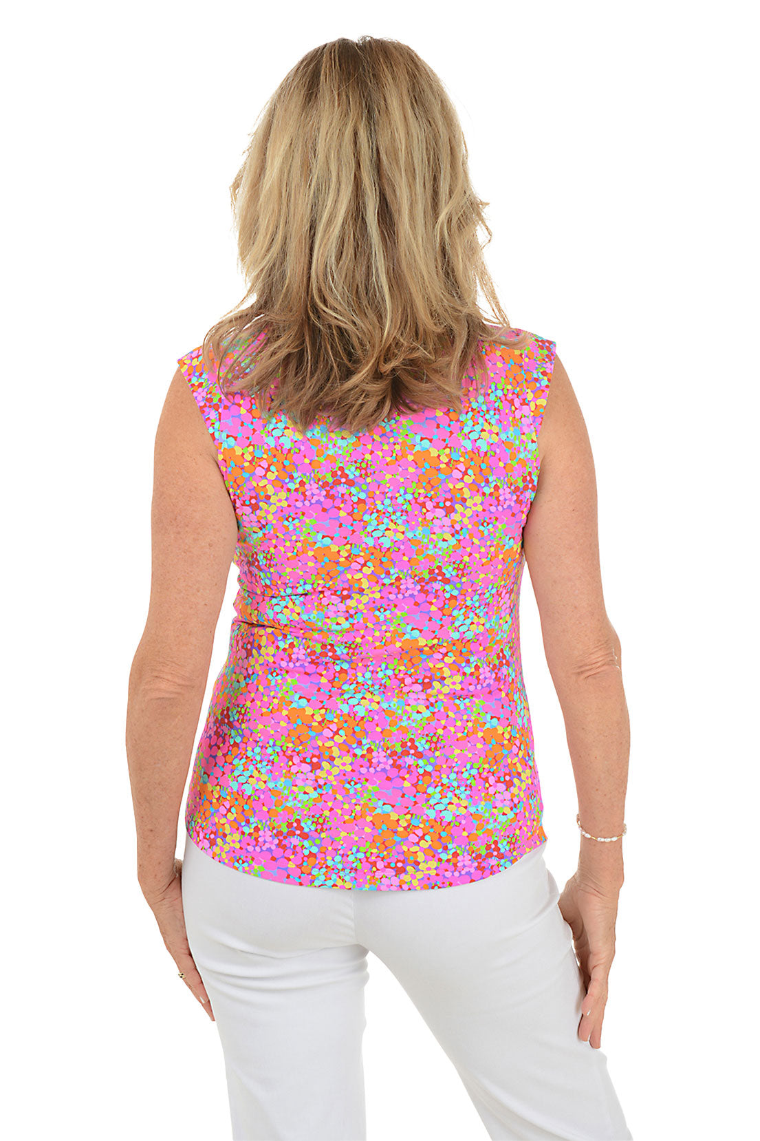 Woman wearing a colorful floral sleeveless blouse on a white background. Back shot.