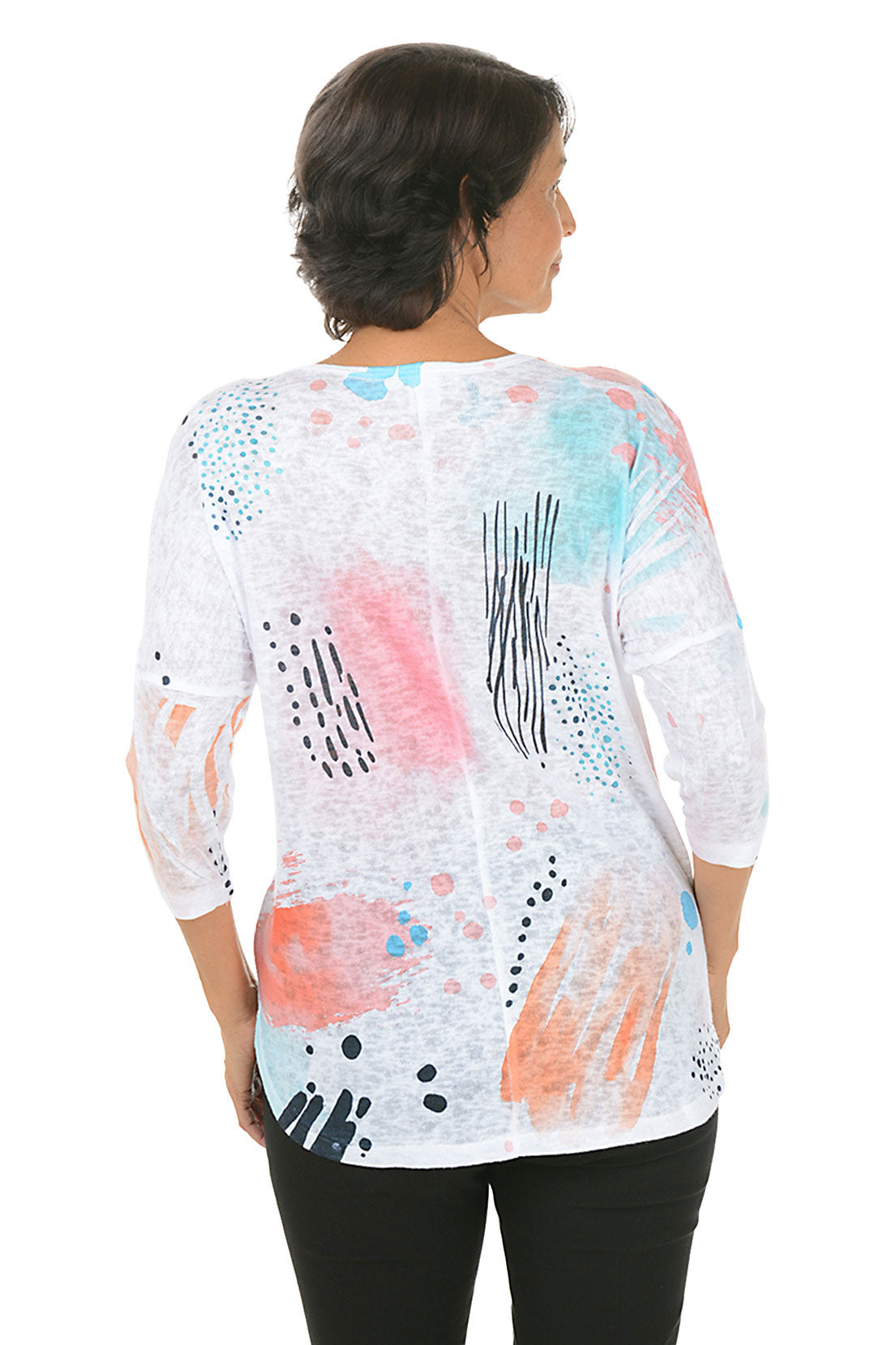 Woman wearing a colorful abstract patterned top on a white background. Back shot.