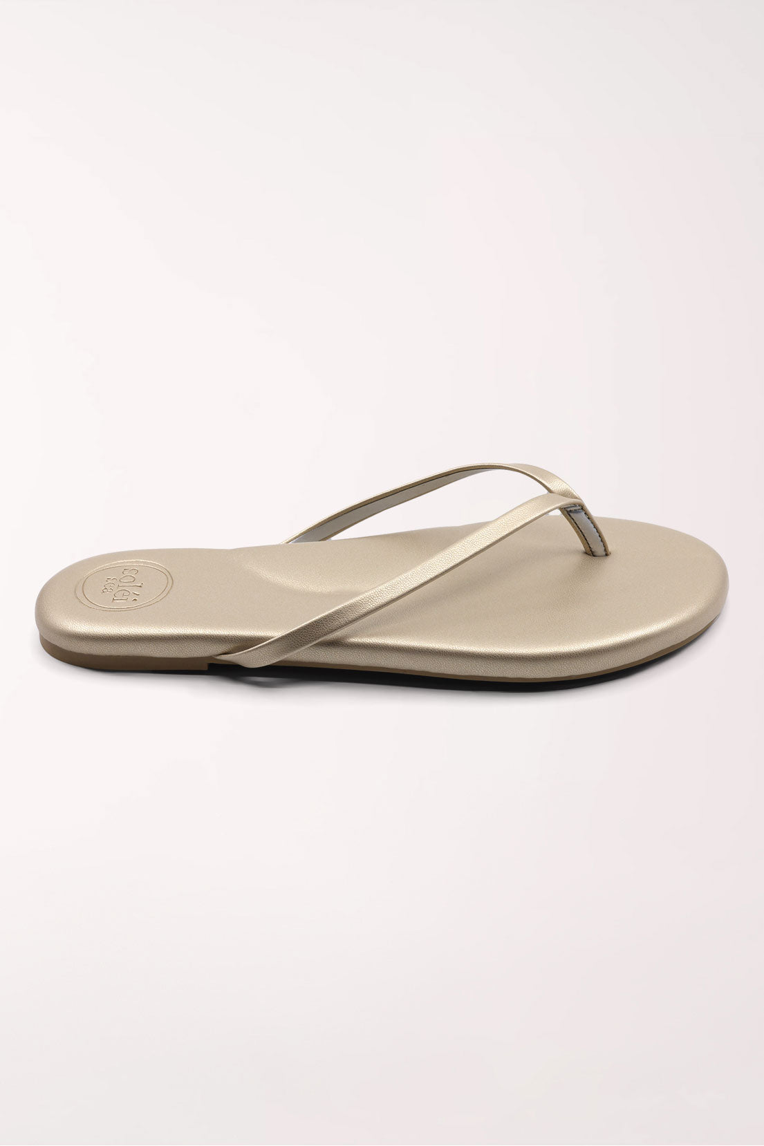 Pair of champagne gold flip-flops on a white background
