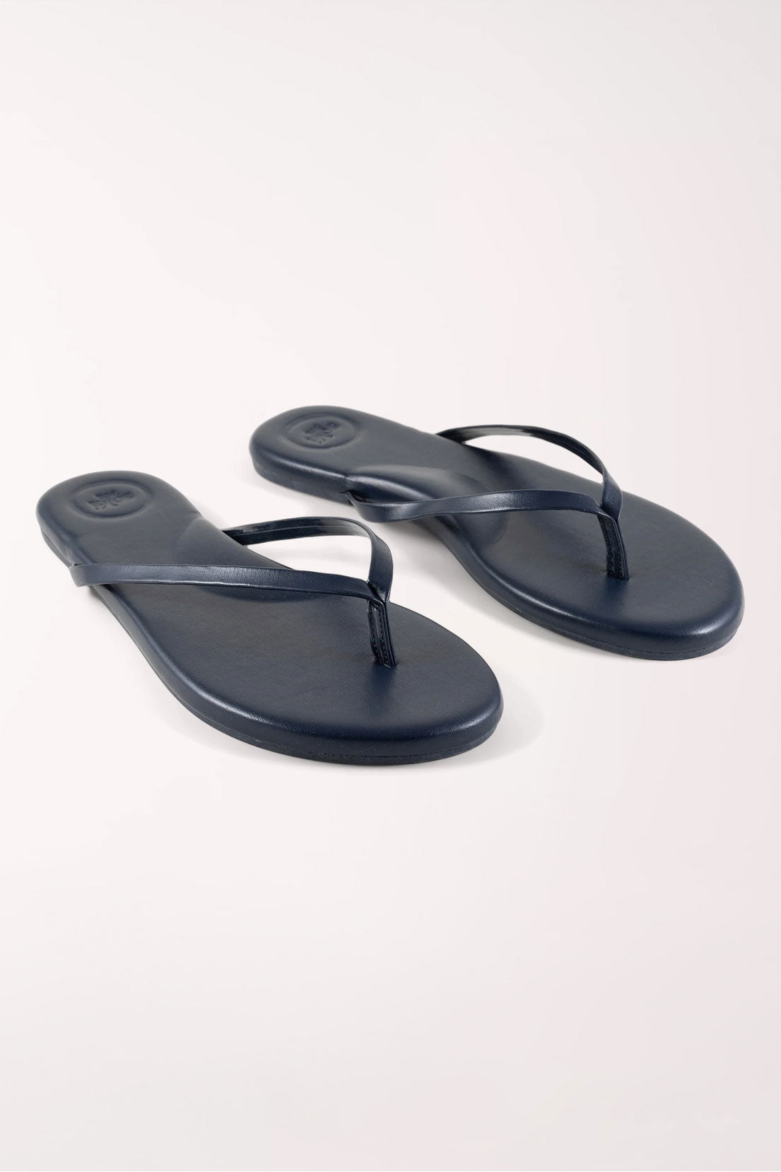Pair of navy blue flip-flops on a white background