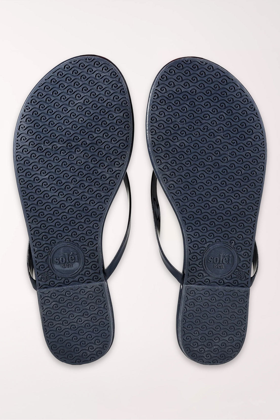 Pair of navy blue flip-flops on a white background