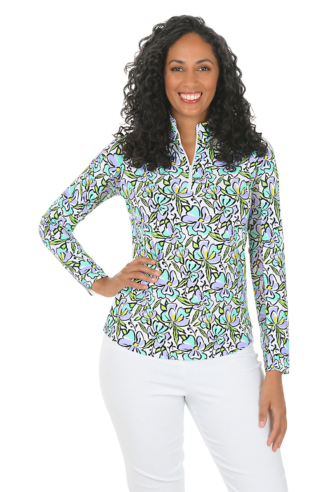 Woman wearing a colorful floral blouse with white pants on a white background.