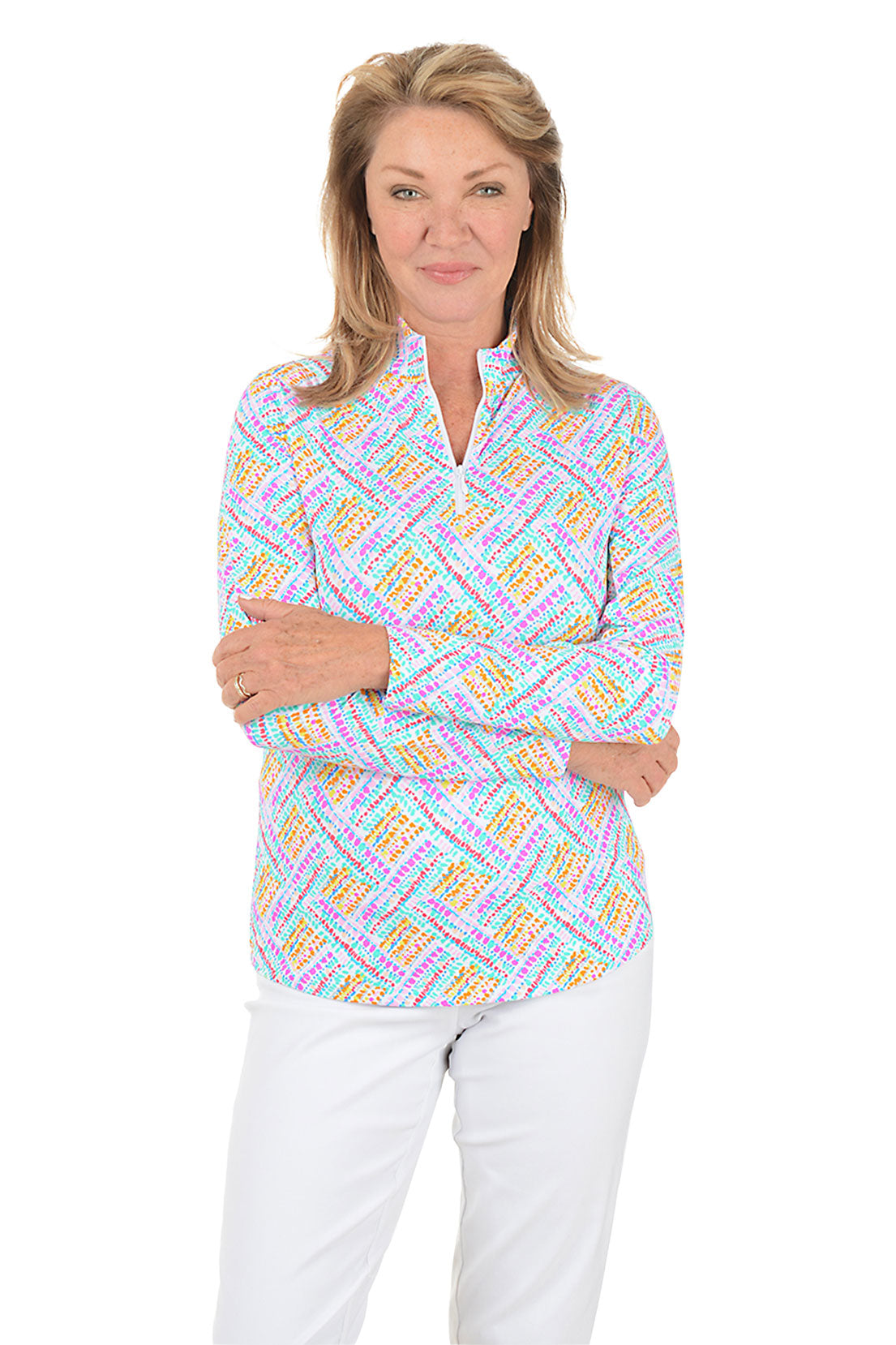 Woman wearing a colorful patterned blouse with white pants on a white background. Second front shot.