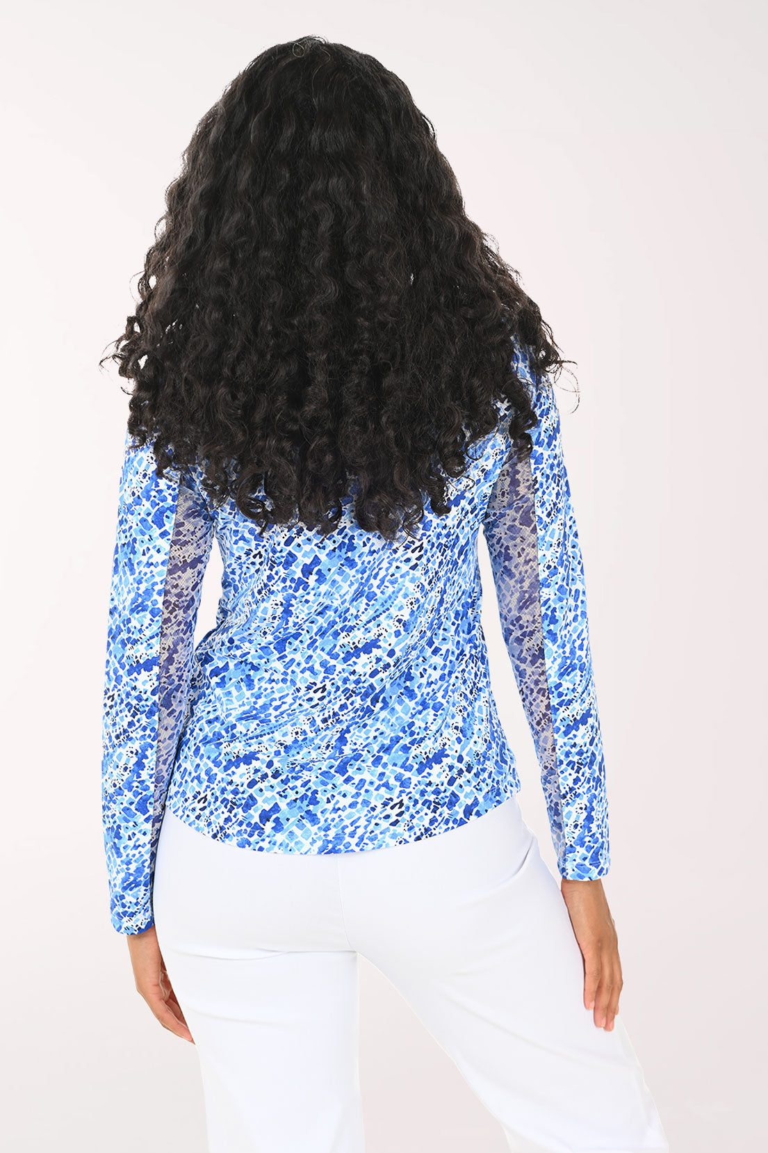 Woman wearing a blue and white patterned pullover against a white background