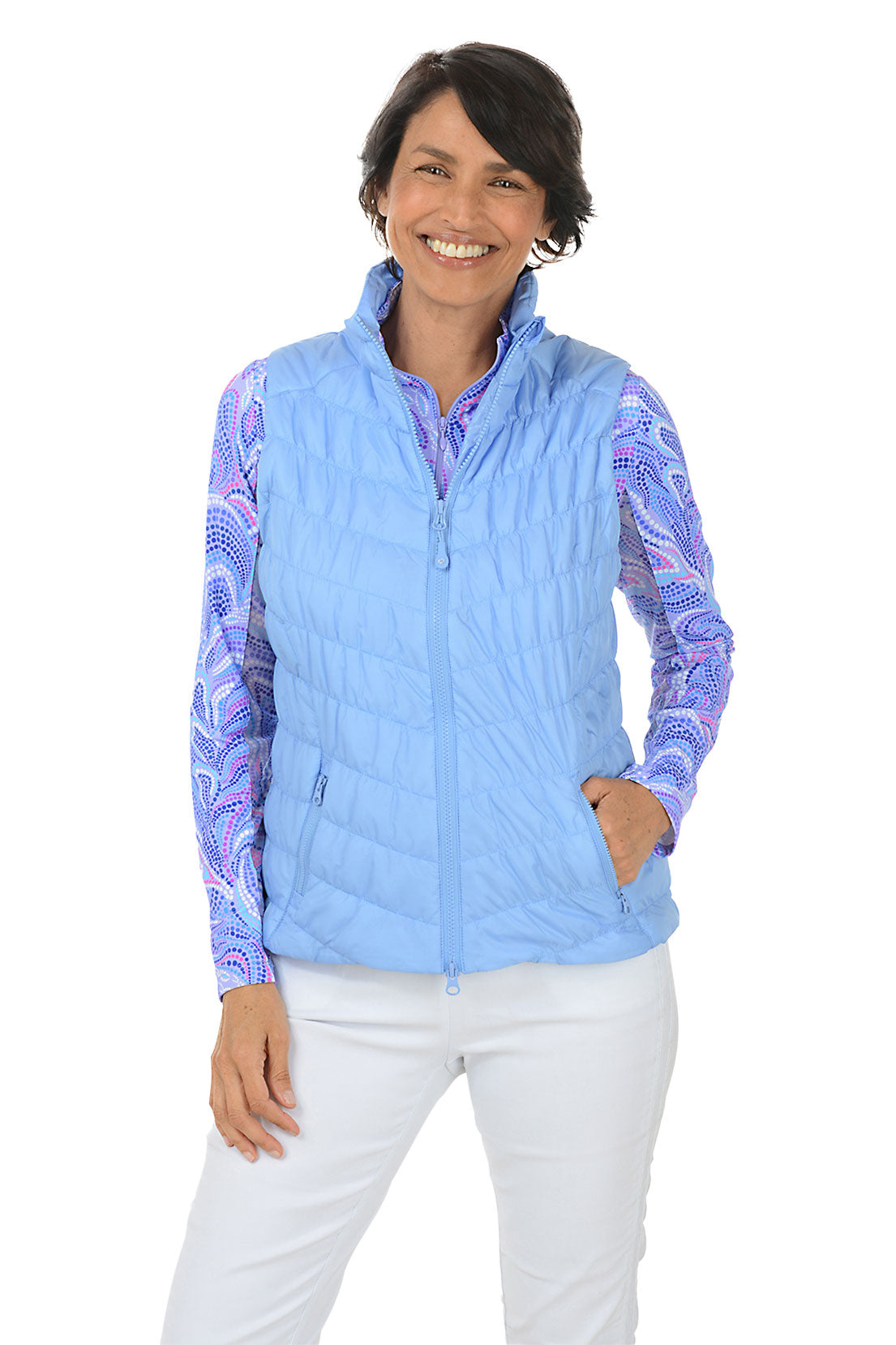 Woman wearing a light blue quilted vest with a colorful pattern on sleeves against a white background.