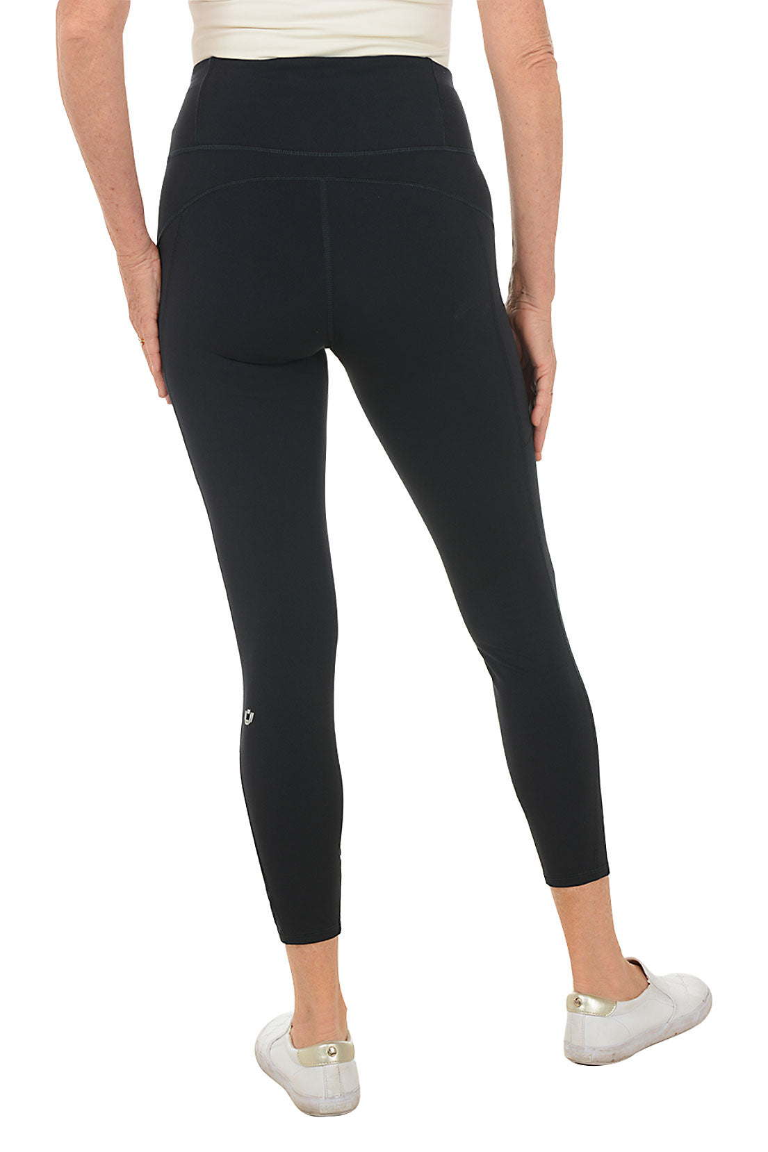 Person wearing black leggings with white accents on a white background. Back shot.