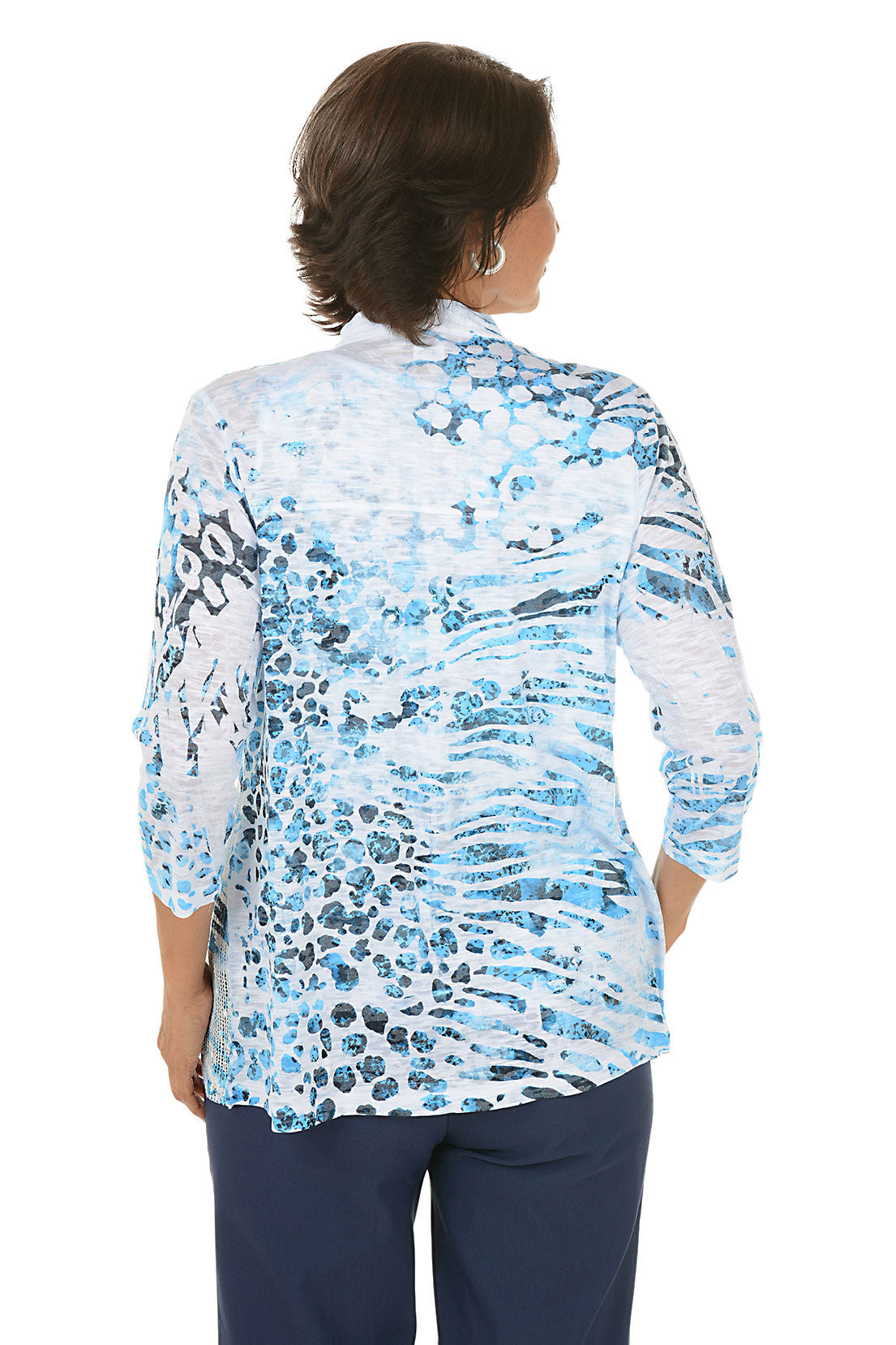 Woman wearing a blue floral cardigan over a white top on a white background. Back shot.