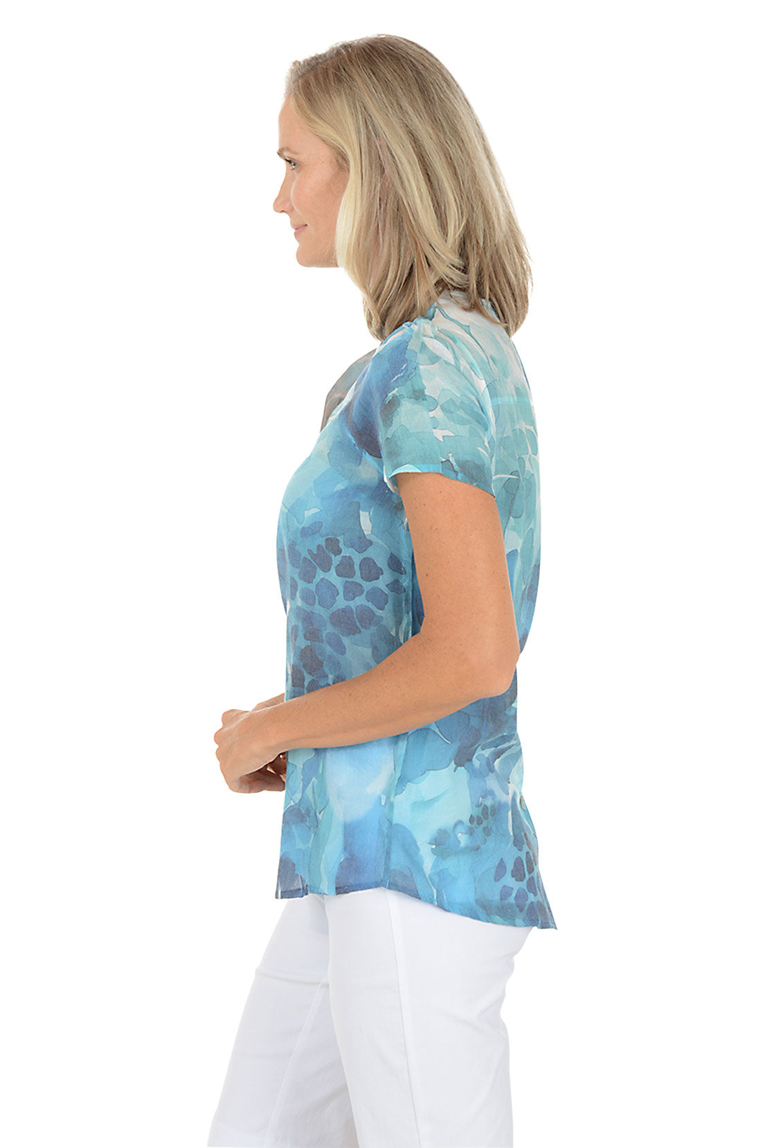 A woman wearing a blue v-neck short sleeve shirt with a button detail. Side shot.