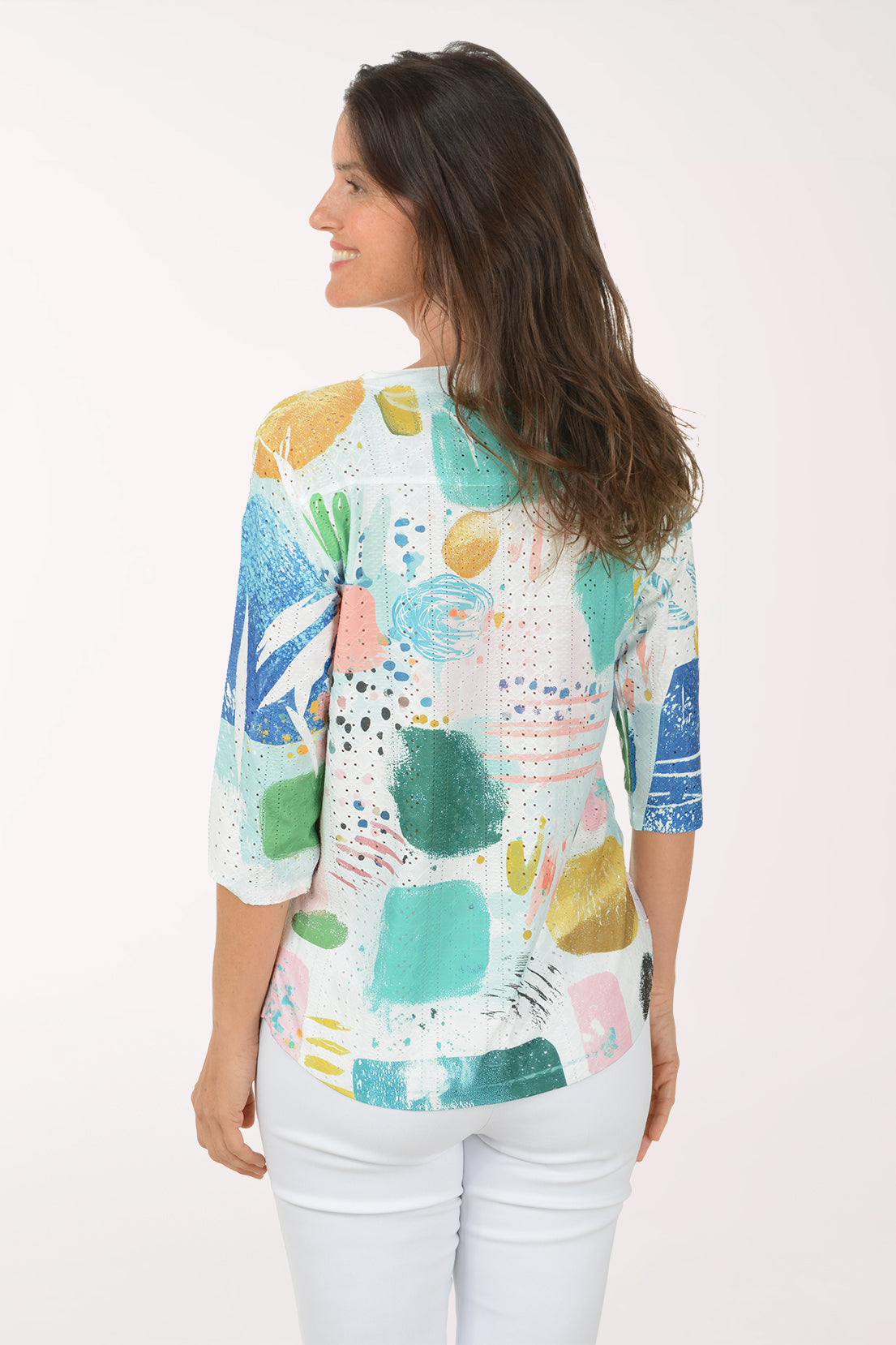 Woman wearing a colorful floral blouse against a white background