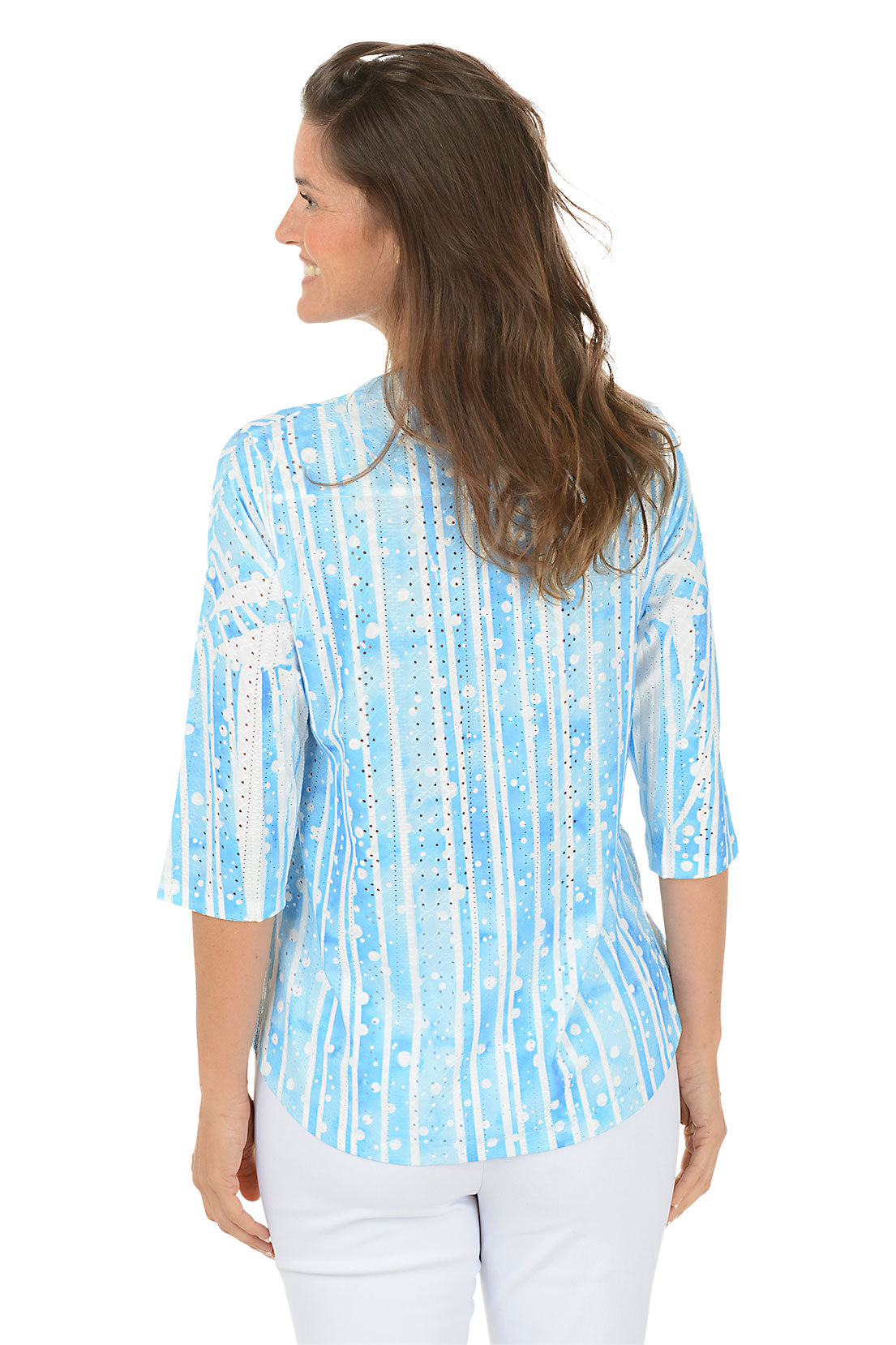 Woman wearing a blue and white patterned blouse on a white background. Back shot.