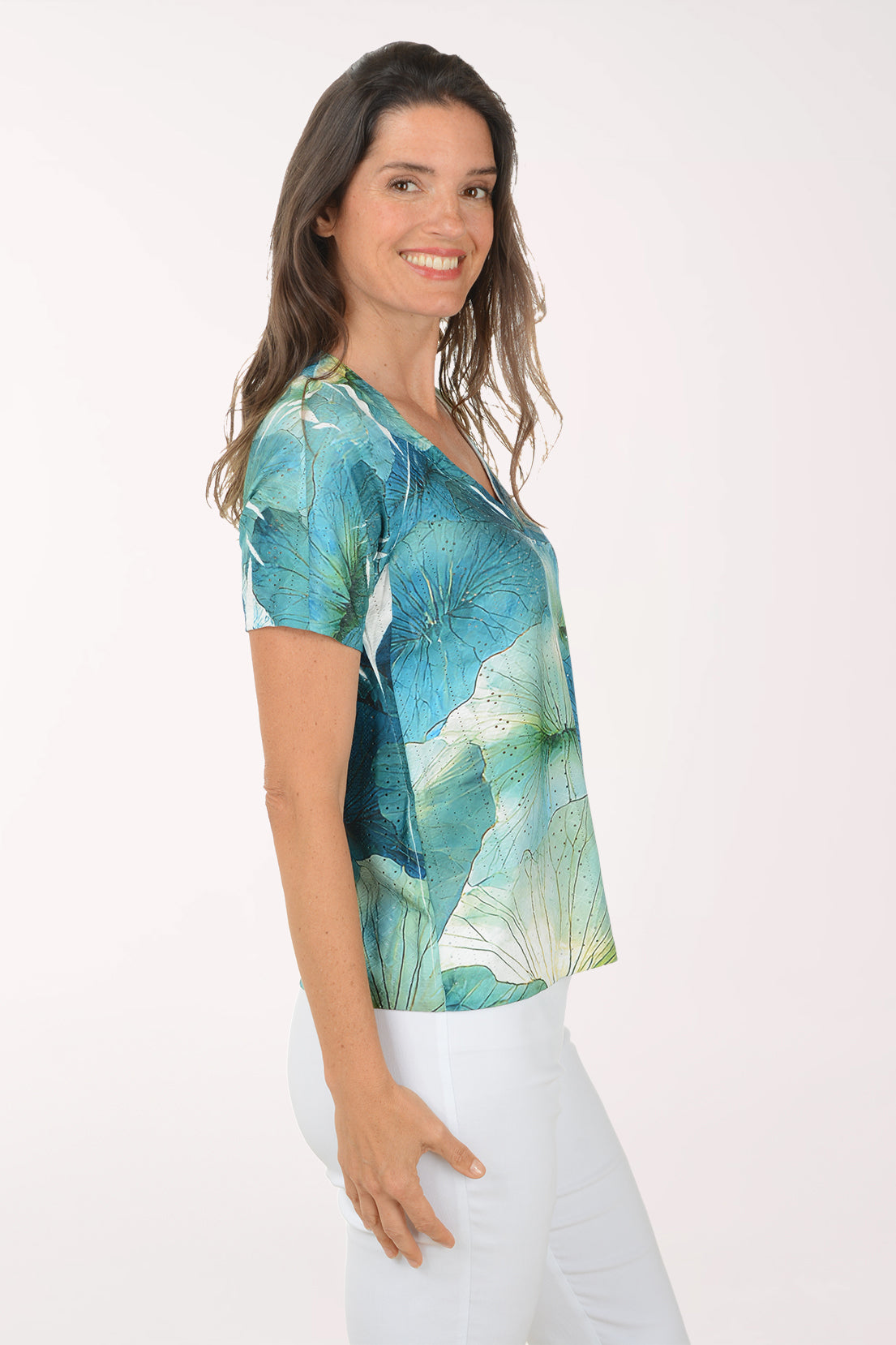 Woman wearing a colorful floral blouse against a white background