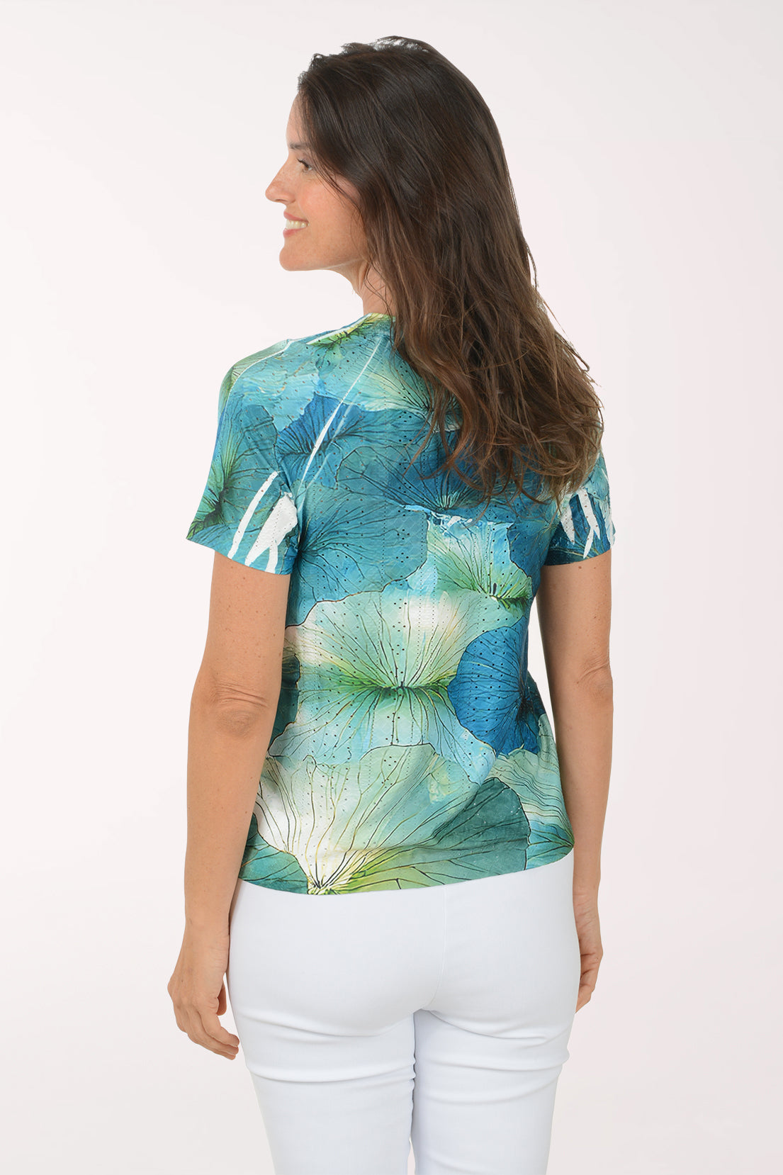 Woman wearing a colorful floral blouse against a white background
