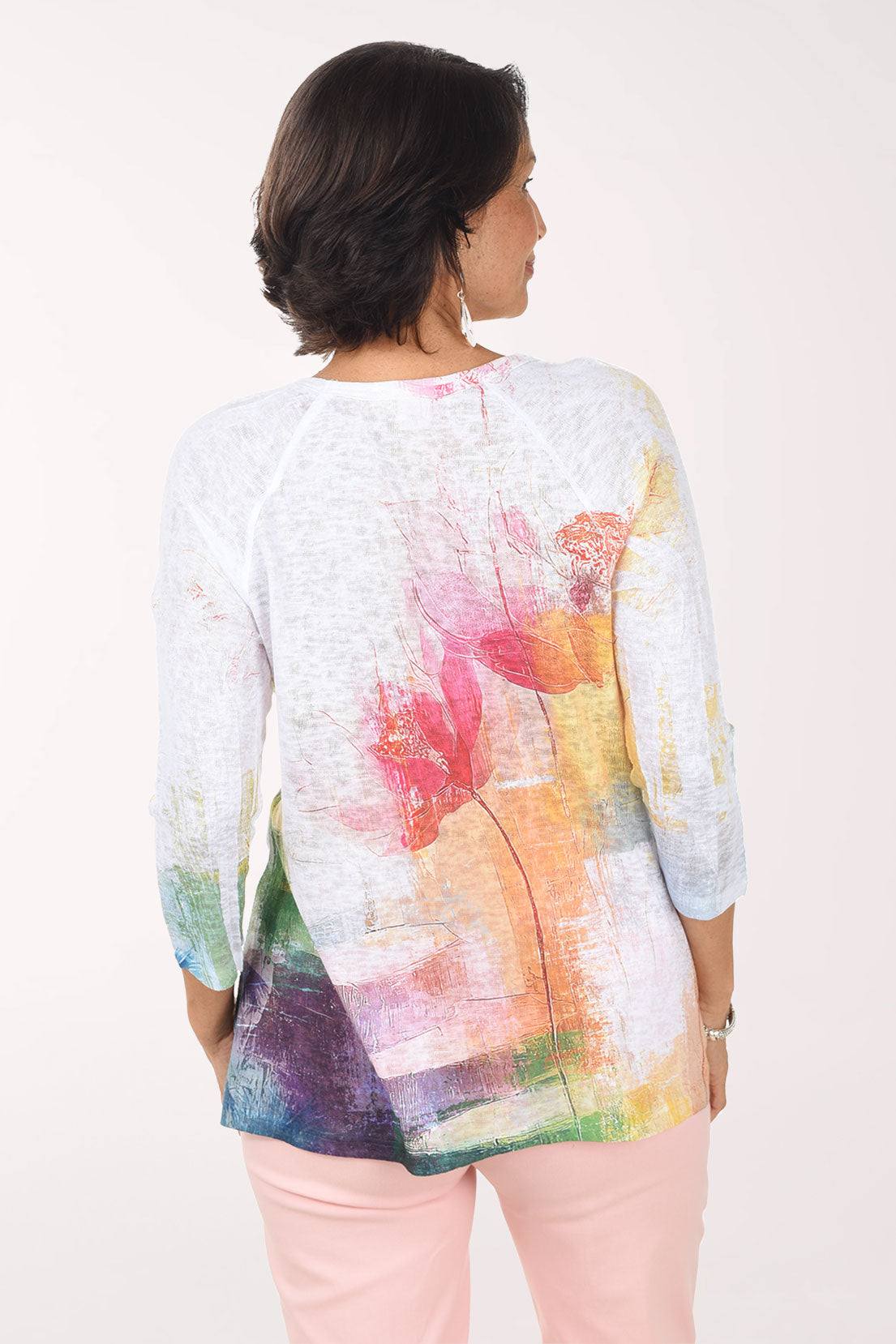 Woman wearing a colorful floral-patterned top on a white background