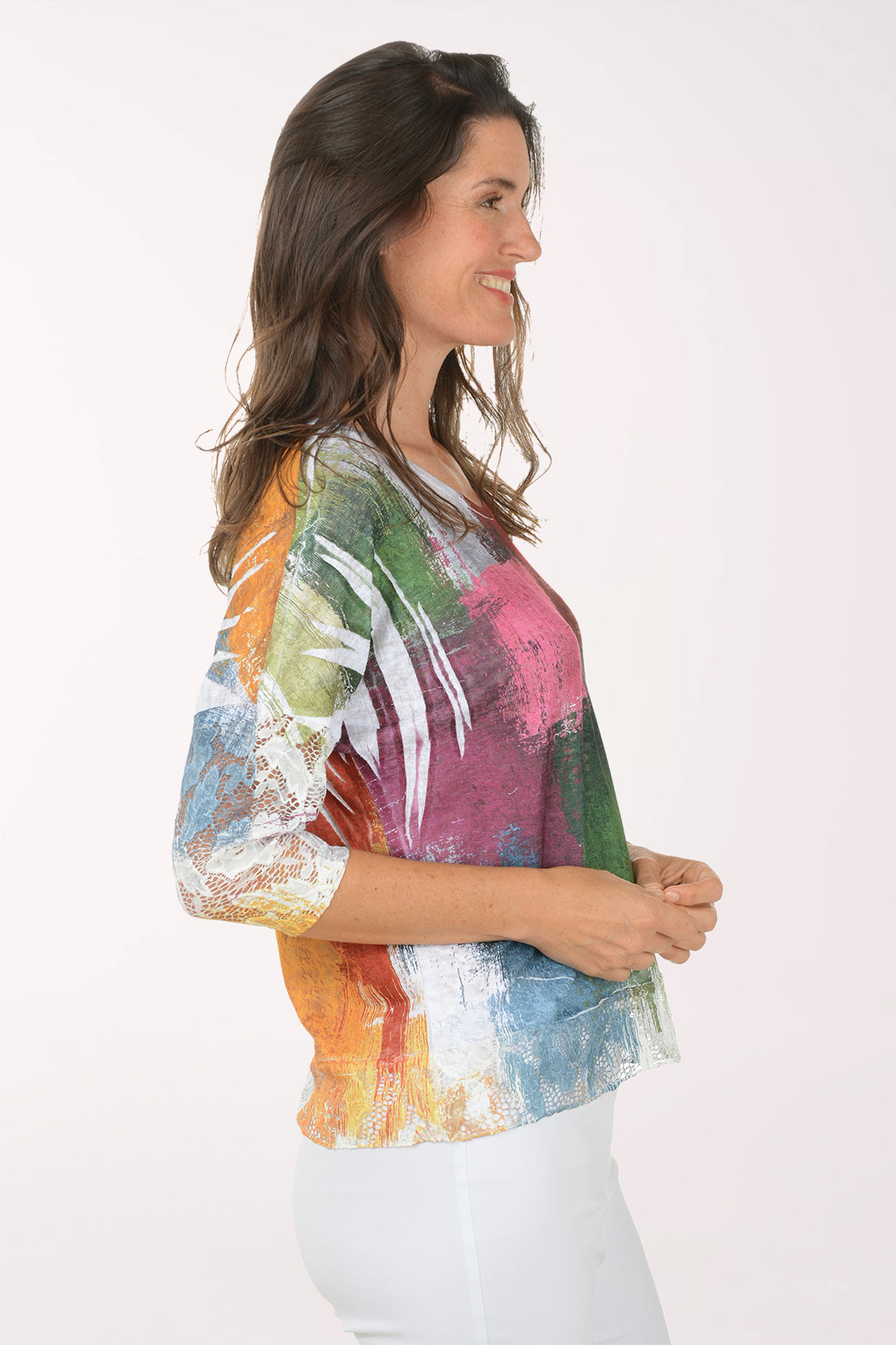 Woman wearing a colorful, patterned top on a white background