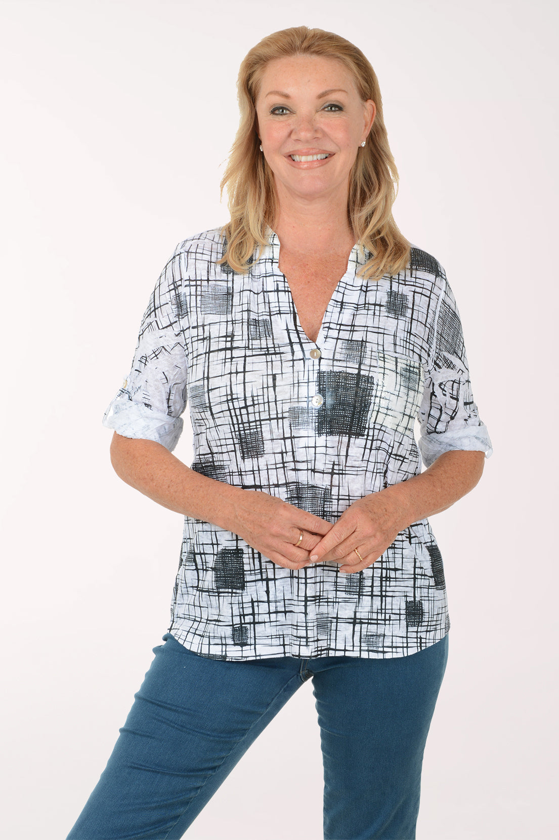 Woman wearing a checkered blouse and blue jeans on a white background