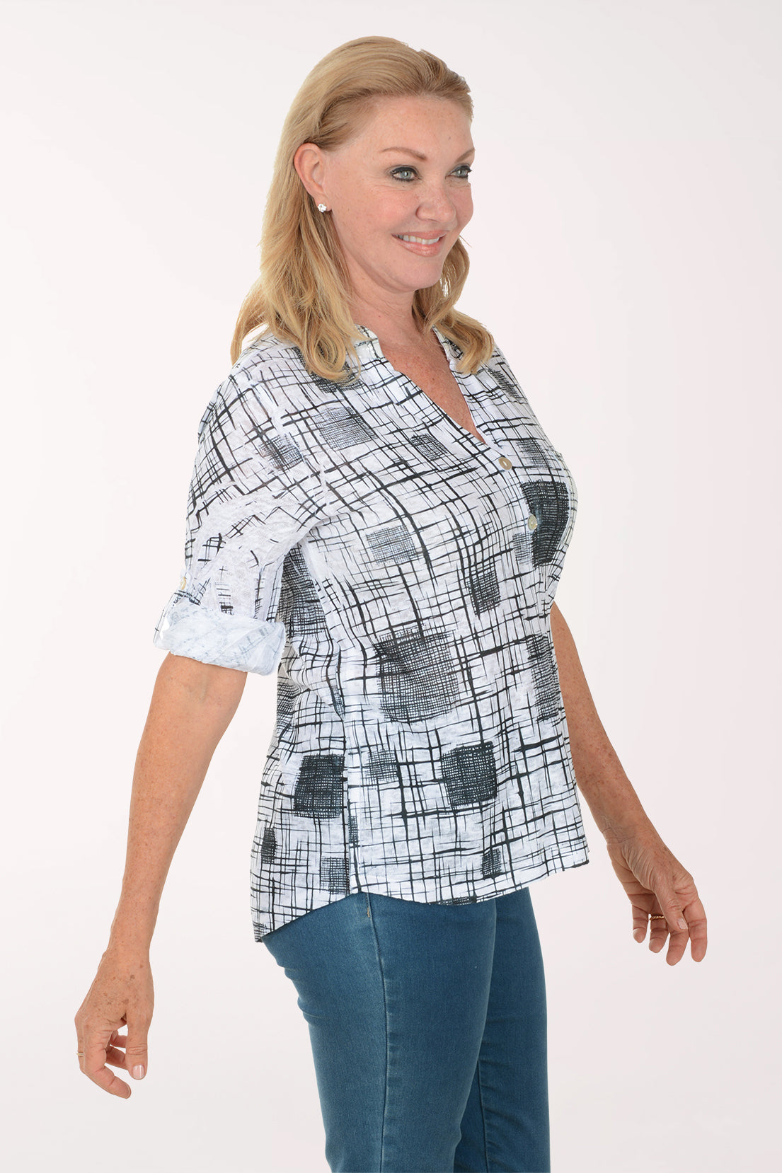 Woman wearing a checkered blouse and blue jeans on a white background
