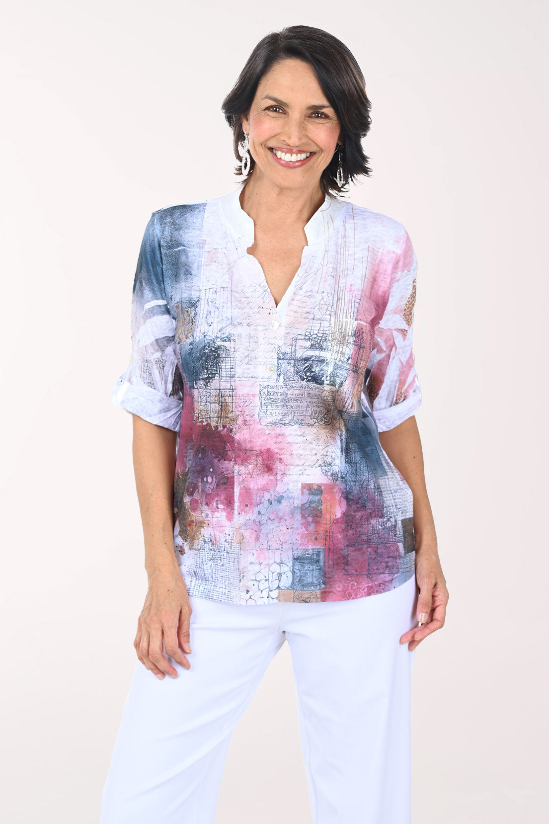 Woman wearing a colorful patterned blouse with a plain background