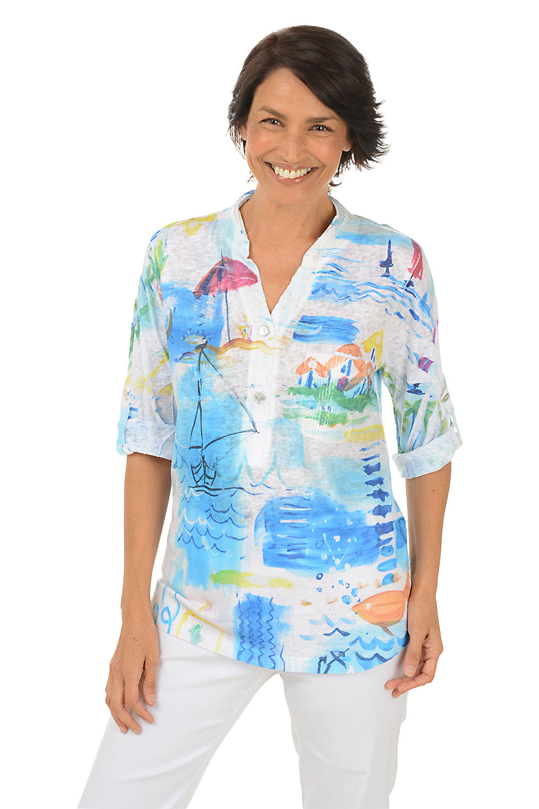 Woman wearing a colorful beach patterned blouse on a white background.