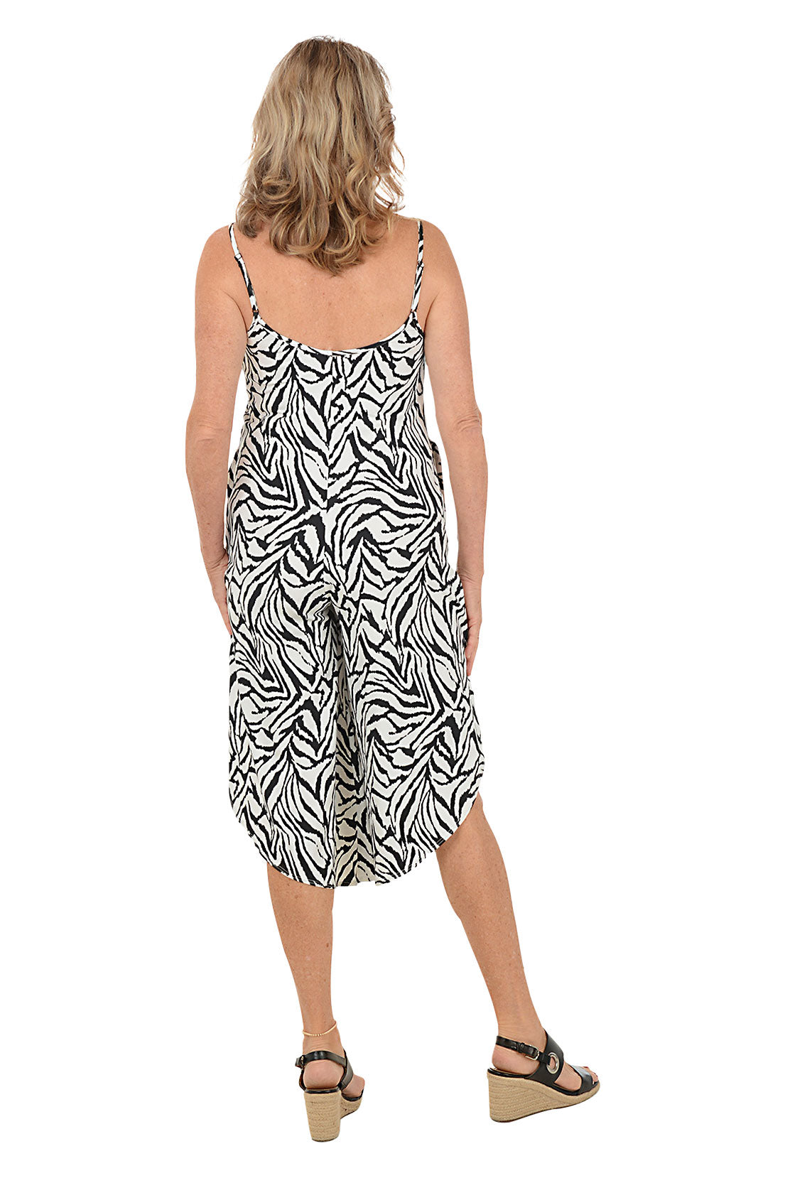 A woman wearing a black and white sleeveless cover-up dress. Back shot.